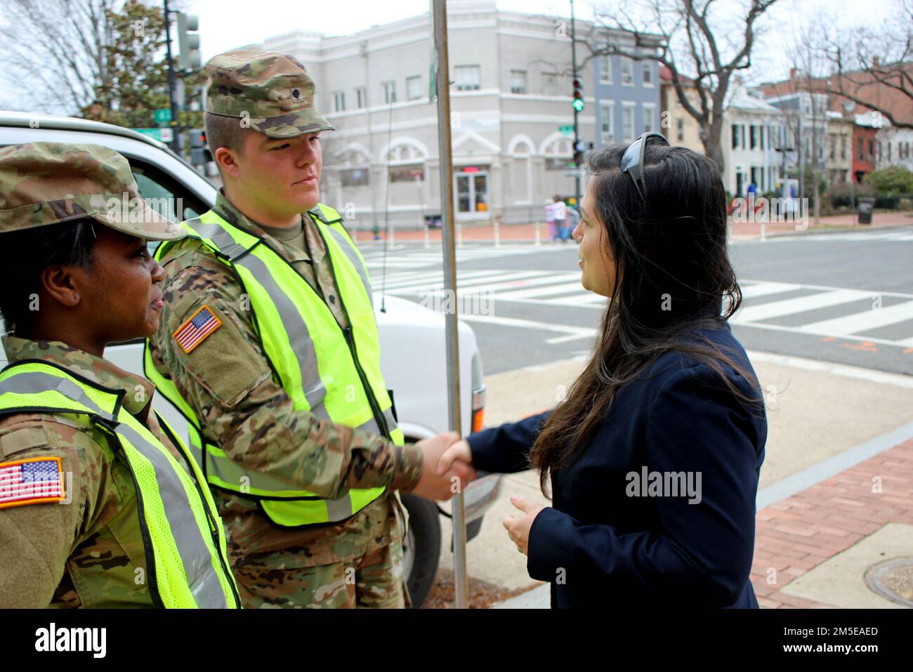 SPC. Justin Gould, ein Mechaniker für Radfahrzeuge bei der 328. Military Police Company, 42. Regional Support Group, New Jersey National Guard, wird begrüßt und von Lori Williams, einer Kollegin des US-Verteidigungsministeriums, aus dem Büro der USA, eine Münze überreicht Rep. Andy Kim bei einer US-Regierung Von der Capitol Police (USCP) ausgewiesener Verkehrskontrollpunkt im District of Columbia, 7. März 2022. Kim ist der Vertreter des 3. Kongressbezirks von New Jersey. Etwa 100 Mitglieder des New Jersey Service wurden aktiviert, um der District of Columbia National Guard bei der Unterstützung von D.C. zu helfen Metro Police und USCP Stockfoto