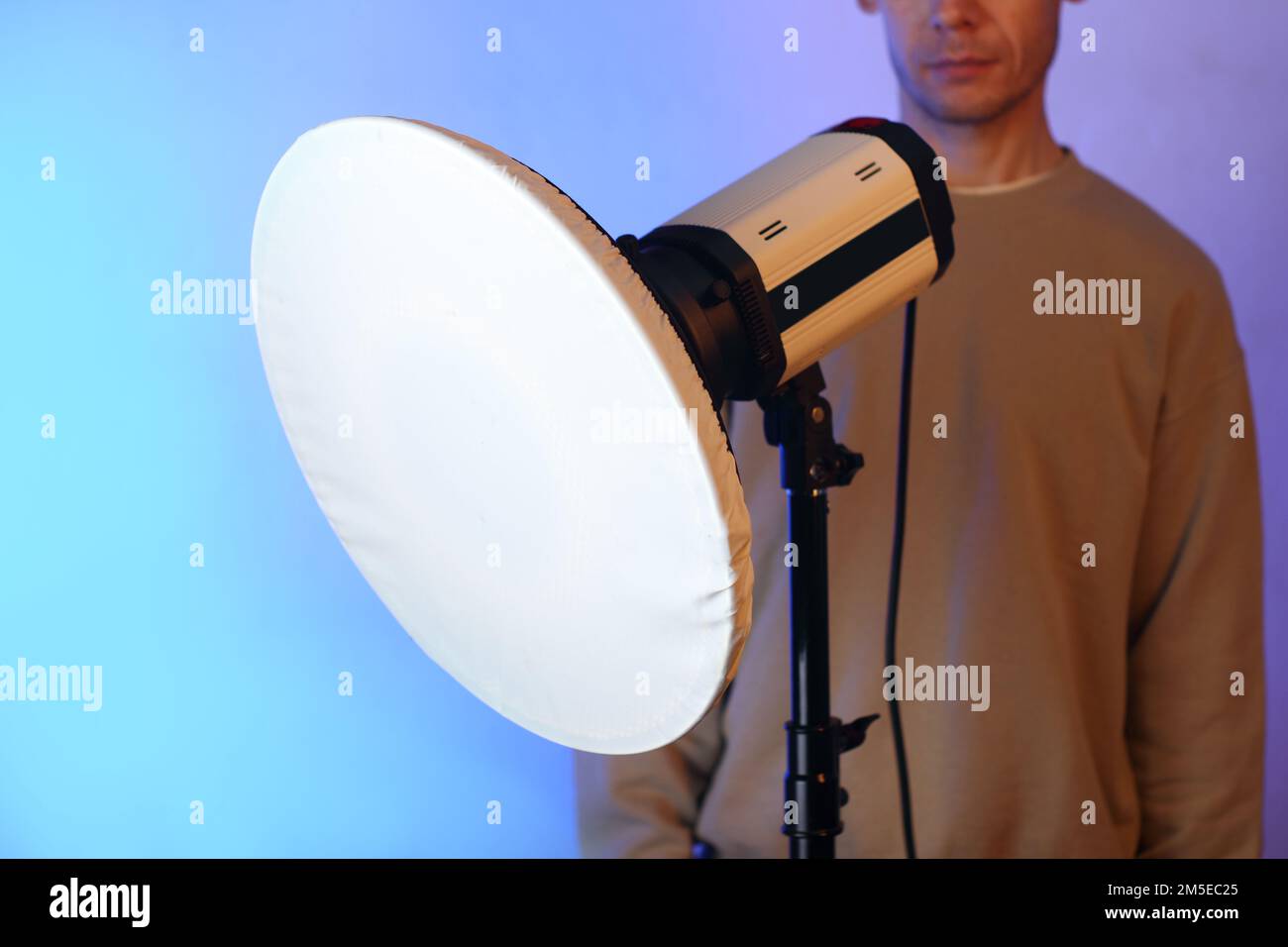 Kosmetikschale mit Diffusor auf Blitz und Person auf blauem Hintergrund Stockfoto