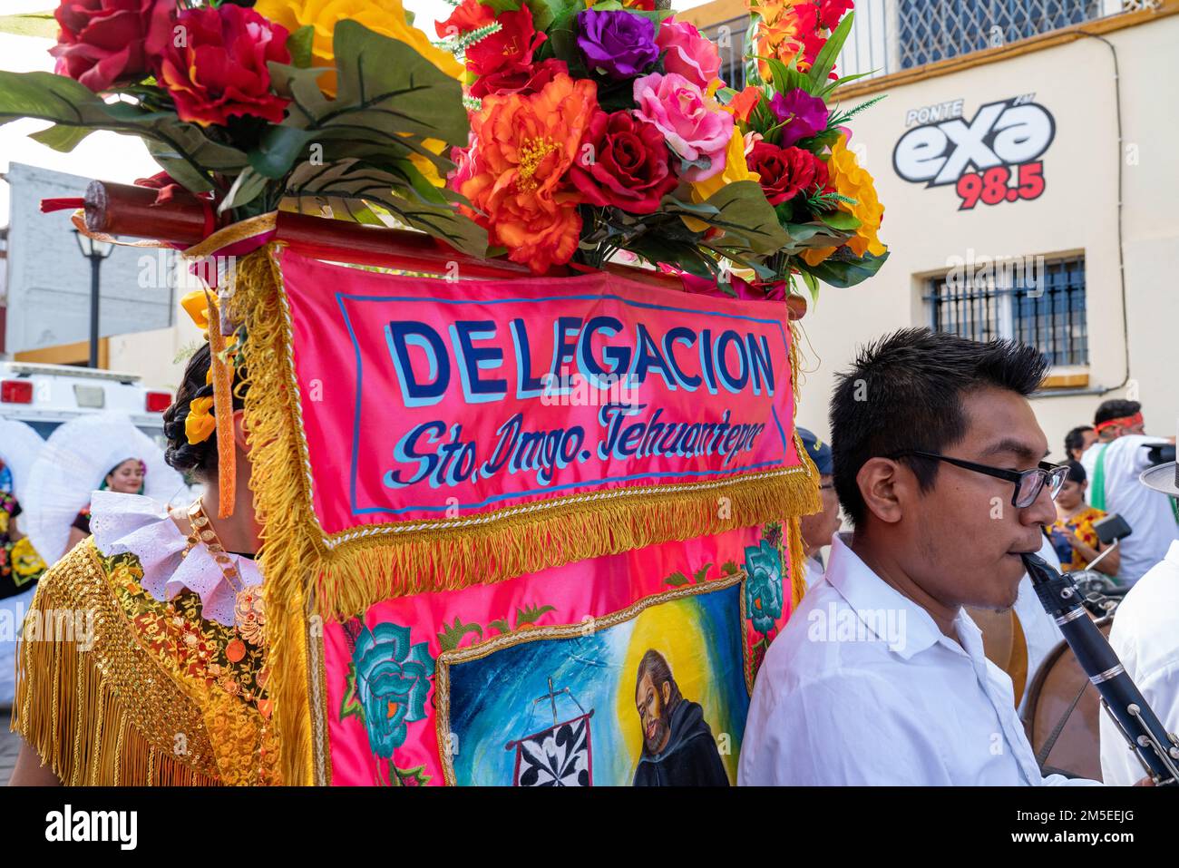 Ein Musiker und Banner für die Tanzgruppe von Santo Domingo Tehuantepec bei einer Guelaguetza-Parade in Oaxaca, Mexiko. Stockfoto