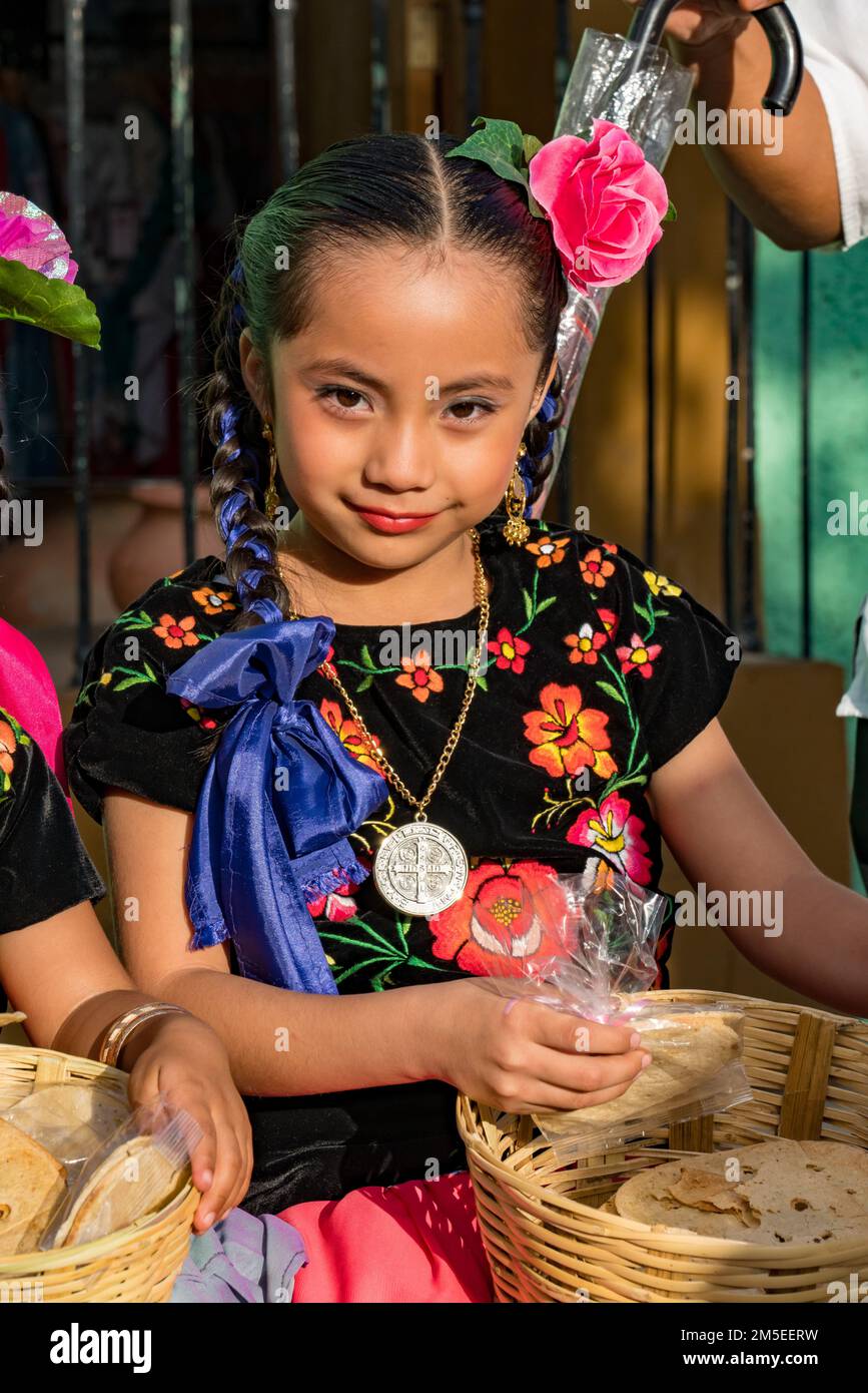 Ein kleines Mädchen in typischen Kleidern vom Isthmus von Tehuantepec wartet auf eine Parade beim Guelaguetza Festival in Oaxaca, Mexiko. Stockfoto