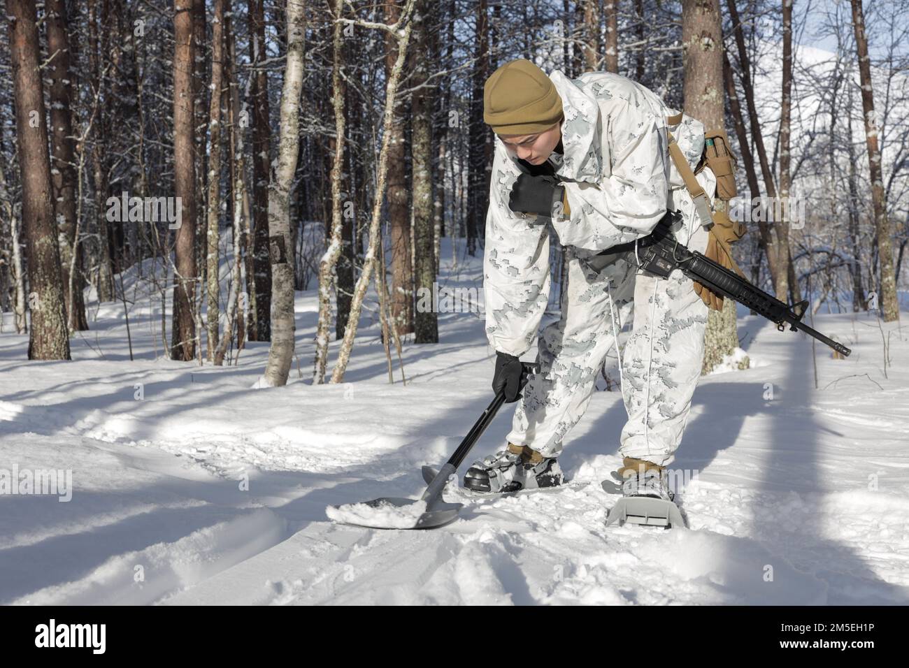 USA Marinekorps Lance CPL. Anthony Zheng, stammt aus Pittsburgh, Pennsylvania, und ist Datensystemadministrator des All Domain Effects Team (ADET), 2. Air Naval Gunfire Liaison Company, II Marine Expeditionary Force Information Group (II MIG), Verwendet eine Schaufel, um seine Schneeräumspuren während einer praktischen Anwendung auf einer Täuschungsstrecke zu verbergen, bevor er am 8. März 2022 in Setermoen, Norwegen, die Cold Response 2022 durchführt. ADETs wurden entwickelt, um Funktionen aus II-MIG zu integrieren, um kinetische und nicht-kinetische Brände zu synchronisieren und so Effekte in Luft-, Land-, See-, Weltraum- und Cyber-Domänen zu erzeugen. Übungen Stockfoto