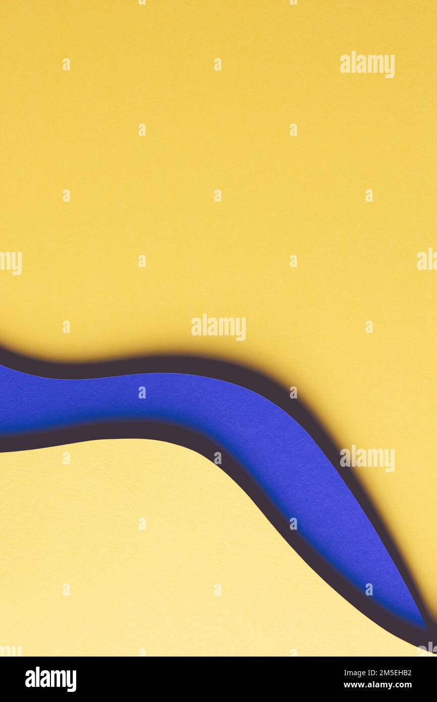 Abstrakter farbiger Papierhintergrund. Minimale Zusammensetzung des Papierschnitts mit Lagen von geometrischen Formen und Linien in Gelb und Blau Stockfoto