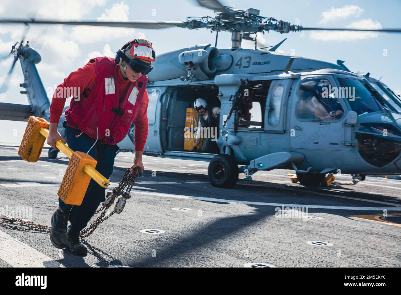 220308-N-GF955-1151 KARIBISCHES MEER - (8. MÄRZ 2022) -- Mineman Seaman Apprentice Aizik Ramirez, dem Küstenschiff der Freiheitsvariante USS Billings (LCS 15) zugeteilt, entfernt Keile und Ketten aus einem MH-60s Sea Hawk Helikopter, der dem ‚Shadow det‘ des Helicopter Sea Combat Squadron (HSC) 28, Einheit 7, während des Flugbetriebs zugewiesen wurde, 8. März 2022. Billings wird in das US-Flottengebiet 4. entsandt, um die Mission der Joint Interagency Task Force South zu unterstützen, zu der auch Missionen zur Bekämpfung des illegalen Drogenhandels in der Karibik und im östlichen Pazifik gehören. Stockfoto