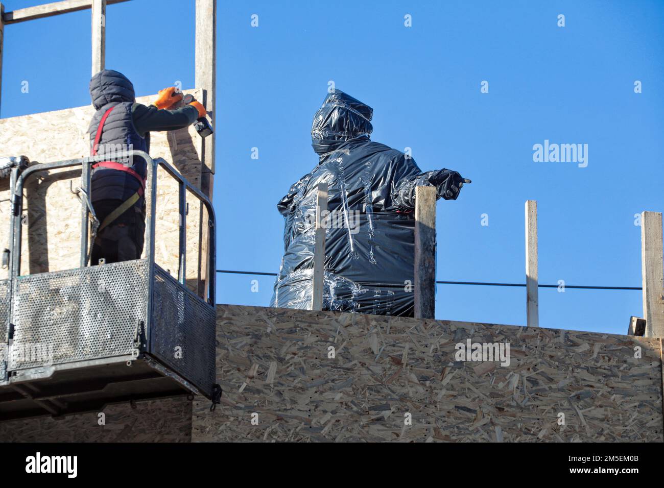ODESA, UKRAINE - 28. DEZEMBER 2022 - Arbeiter von Versorgungsunternehmen verwenden eine Hubarbeitsbühne, um Spanplatten zu entfernen, die den bis zu den Gründern von Odesa monu versiegeln Stockfoto