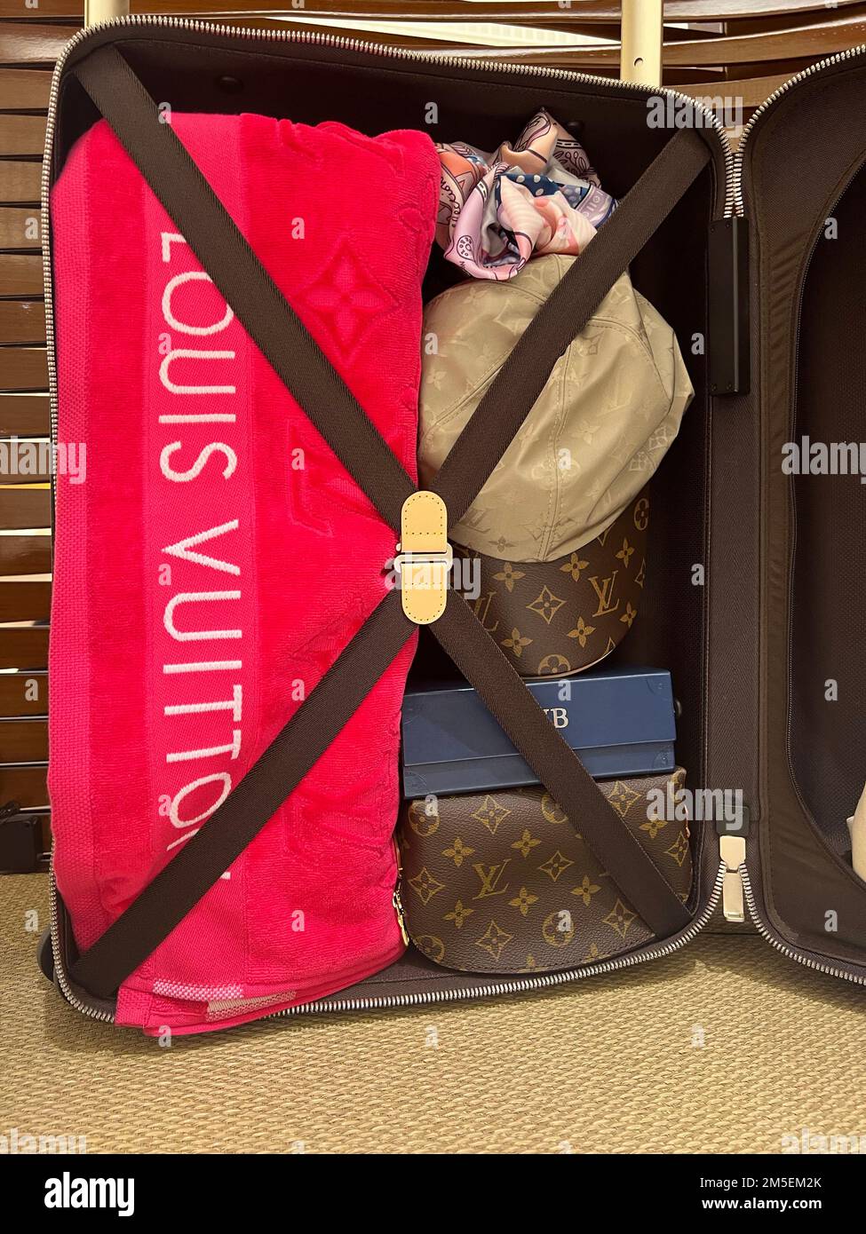 Honolulu, HI - 26. Dezember 2022: Louis Vuitton Designer-Accessoire-Set mit Handtuch, Mütze und Koffer Stockfoto