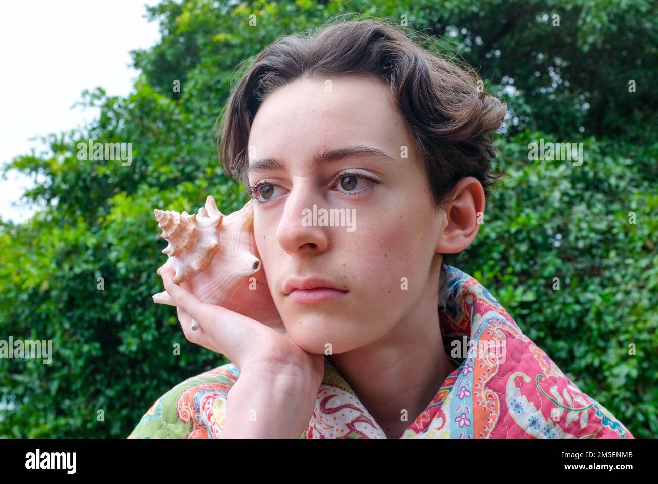 Ein weißer Teenager mit einer riesigen Muschel Stockfoto