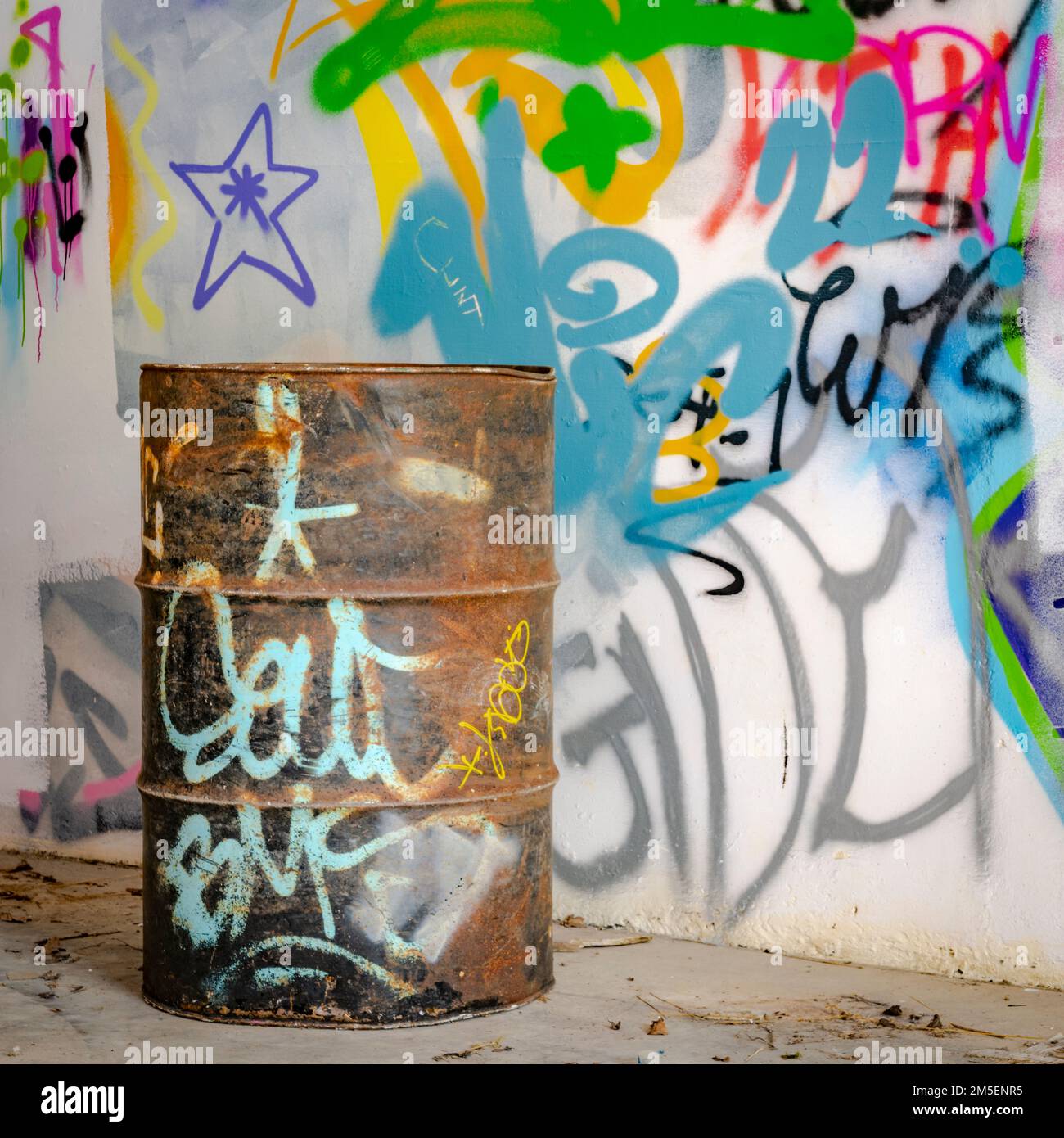 Rostiges Ölfass an einer veredelten Wand in einem verlassenen Gebäude Stockfoto