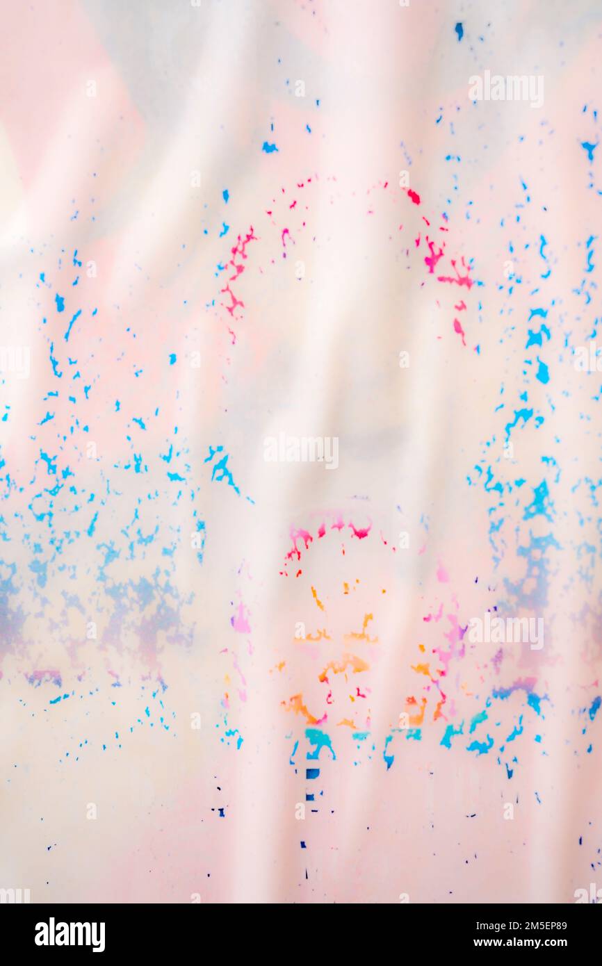 Abstraktes Bild im Porträtformat von pastellfarbenen Flecken auf nassweißem Stoff Stockfoto
