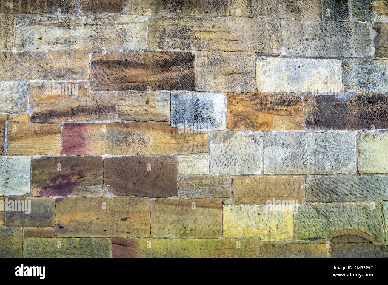 Alte Ufermauer mit wunderschönen farbigen Steinen Stockfoto