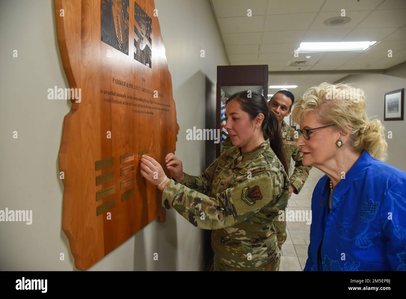 USA Air Force Staff Sergeant Kyana Mamahua, 74. Kampfgeschwader Nachrichtendienst, leitender Offizier, Left, setzt ihren Namen auf die Ausstellung des Parker und Dr. Lucy Greene Service Award mit Dr. Lucy Greene, rechts, 8. März 2022, auf der Moody Air Force Base, Georgia. Die Ausstellung befindet sich im Hauptgebäude des 23. Flügels, um die Leistungen der Airmen zu würdigen, die diese Auszeichnung erhalten haben. Stockfoto