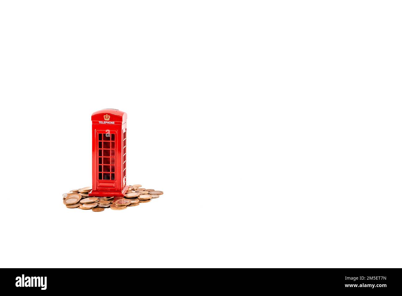 Rote Telefonzelle Geldkassette london, Penny oder Sparschwein auf Münzen auf weißem Hintergrund. Sparen Sie Geld Concept Idea Photo hd. Münzen und Spargeld. Stockfoto