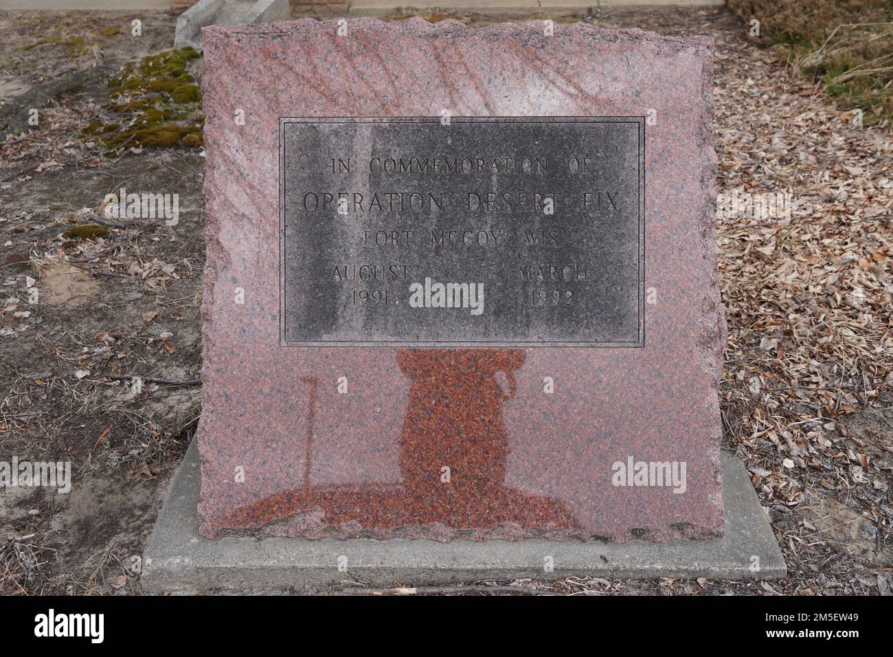 Vor einer Einrichtung in Fort McCoy, Wisconsin, befindet sich ein Schild mit Graniteinprägung, das die Arbeit zur Unterstützung der Operation Desert Fix dokumentiert. Stockfoto