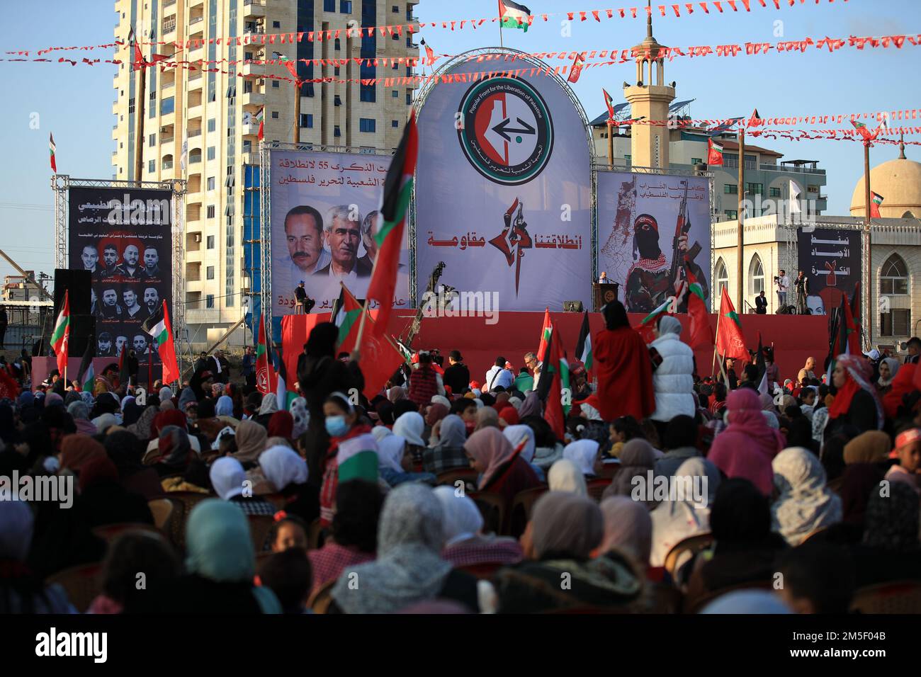 Palästinensische Anhänger der Popular Front for the Liberation of Palestine (PFLP) tragen karierte "Kafiyeh"-Kopfschmuck, wenn sie in Gaza feiern. Palästina. Stockfoto