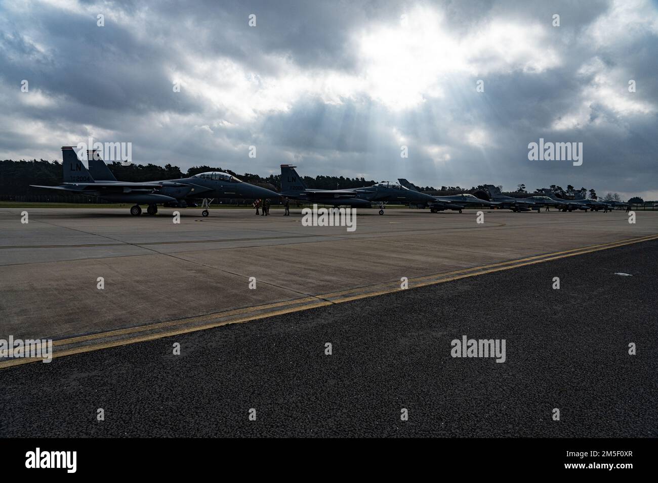 USA Air Force F-15E Strike Eagles, der 494. Kampfgeschwader zugeteilt, und F-16 Fighting Falcons, die der 510. Kampfgeschwader zugeteilt sind, stehen vor dem Start in Royal Air Force Lakenheath, England, am 9. März 2022 auf einer Waffenstelle. Der 48. Fighter Wing, die Gasteinheit der RAF Lakenheath, arbeitet regelmäßig mit Partnereinheiten in ganz Europa zusammen, um die Interoperabilität zu vertiefen und die transatlantische Allianz zu stärken. Stockfoto