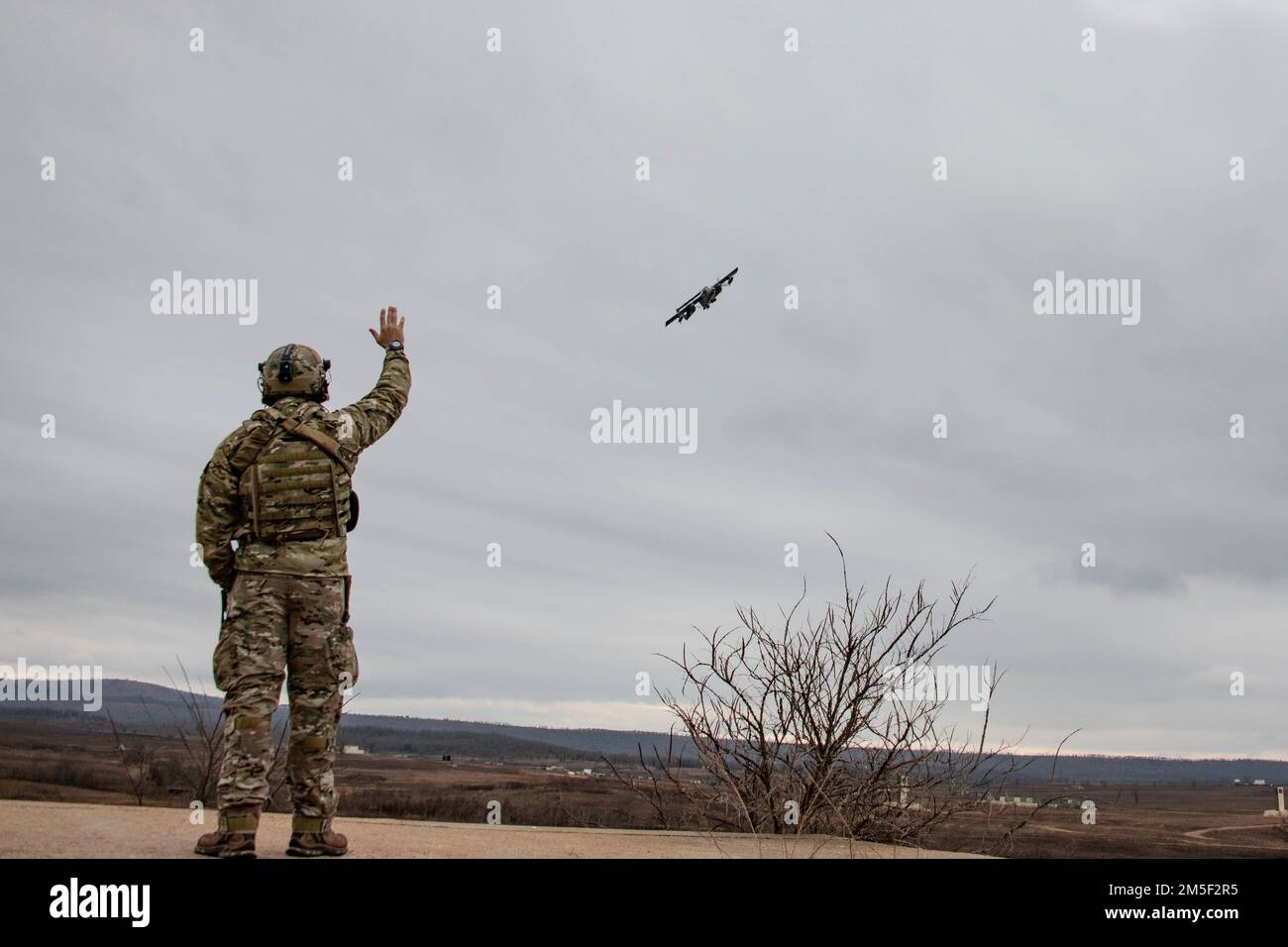 USA Air Force Senior Airman Sean Seefeldt, ein Spezialist für taktische Luftkontrolle, mit dem 13. Air Support Operations Squadron, winkt zu einer Blue Air, die sich mit der Luftunterstützung OV-10 Bronco zusammengeschlossen hat, während sie über das Razorback Range bei Fort Smith, Arkansas, fliegt. Während des gesamten Missionstrainings am Razorback Range bei Fort Smith, Arkansas, am 1. Februar 2022. Dies war die erste Veranstaltung der Airmen vor Ort, während sie an einem gemeinsamen Qualifizierungskurs für Angriffslotsen im Terminal teilnahmen, der von der 137. Combat Training Flight, Oklahoma Air National Guard, durchgeführt wurde. Stockfoto