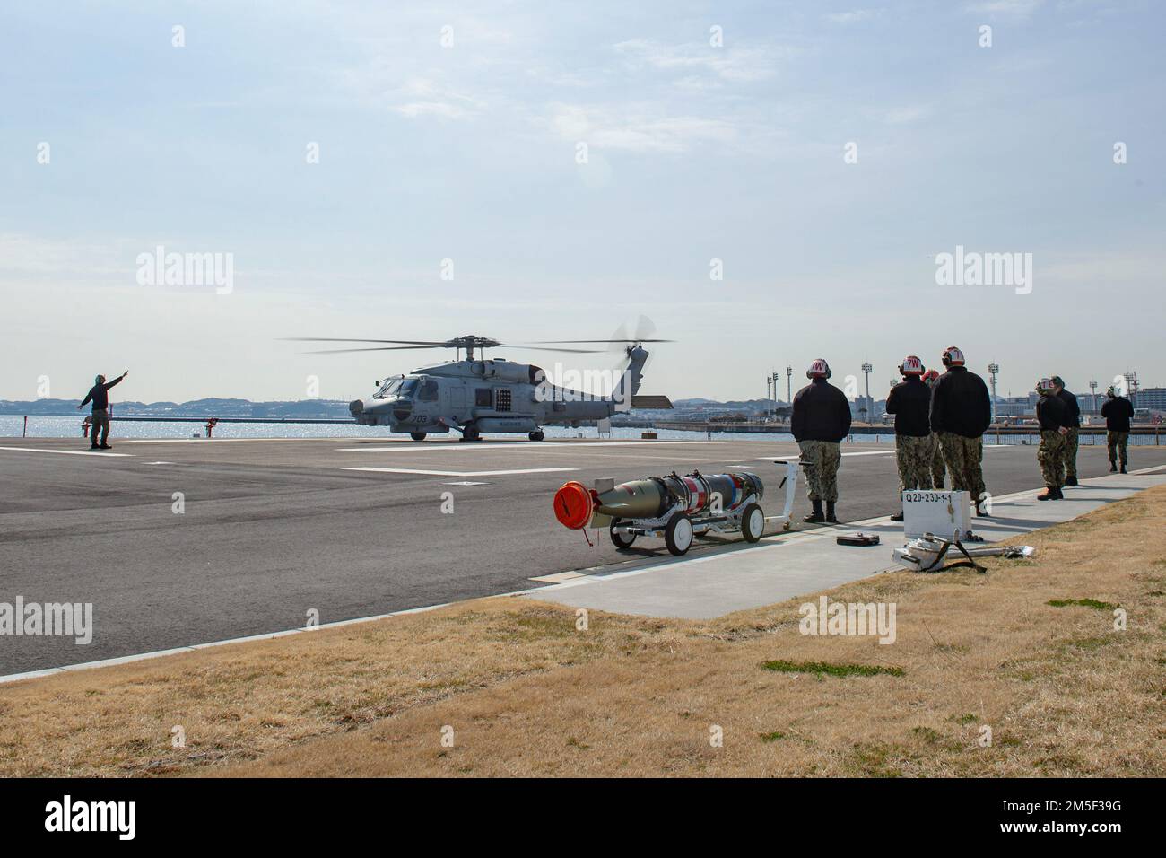 YOKOSUKA, Japan (10. März 2022) Matrosen, die den „Saberhawks“ des Helicopter Maritime Strike Squadron (HSM) 77 zugeteilt wurden, bereiten sich während einer Übung am Kommandanten Flottenaktivitäten Yokosuka auf die Anbringung eines leichten Torpedo MK 54 an einen MH-60R Seahawk vor. Der MK 54 ist ein inerter Trainingstorpedo, der für Übungen wiederverwendet werden kann. HSM-77 ist dem Kommandeur der Task Force 70 angeschlossen und im Zuständigkeitsbereich der US-7.-Flotte zur Unterstützung eines freien und offenen Indo-Pacific eingesetzt. Stockfoto