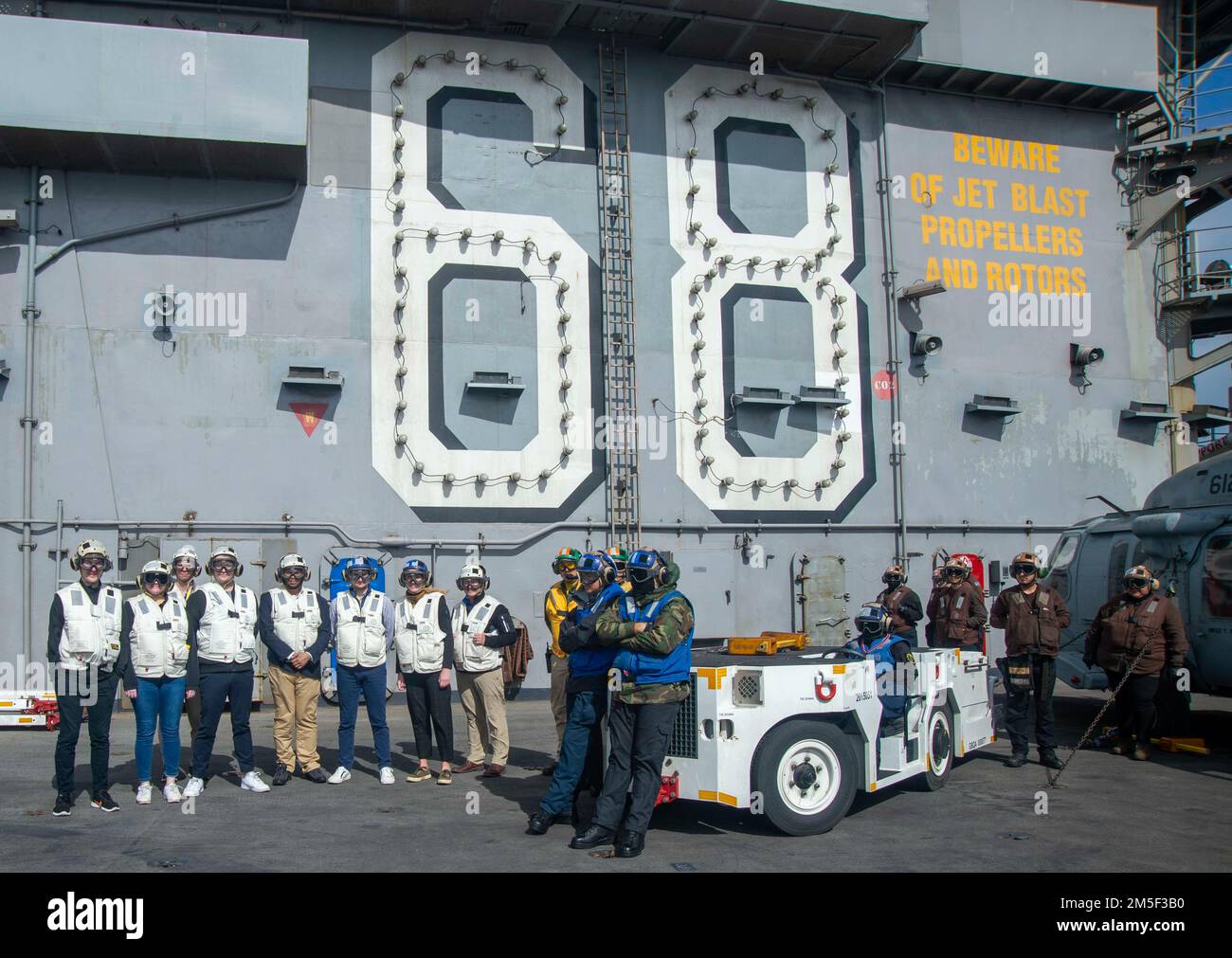 220308-N-YS933-1311 PAZIFIK (10. MÄRZ 2022) Ehrenwerte Besucher beobachten den Flugbetrieb an Bord der USS Nimitz (CVN 68). Nimitz führt gerade Routineoperationen durch. Stockfoto