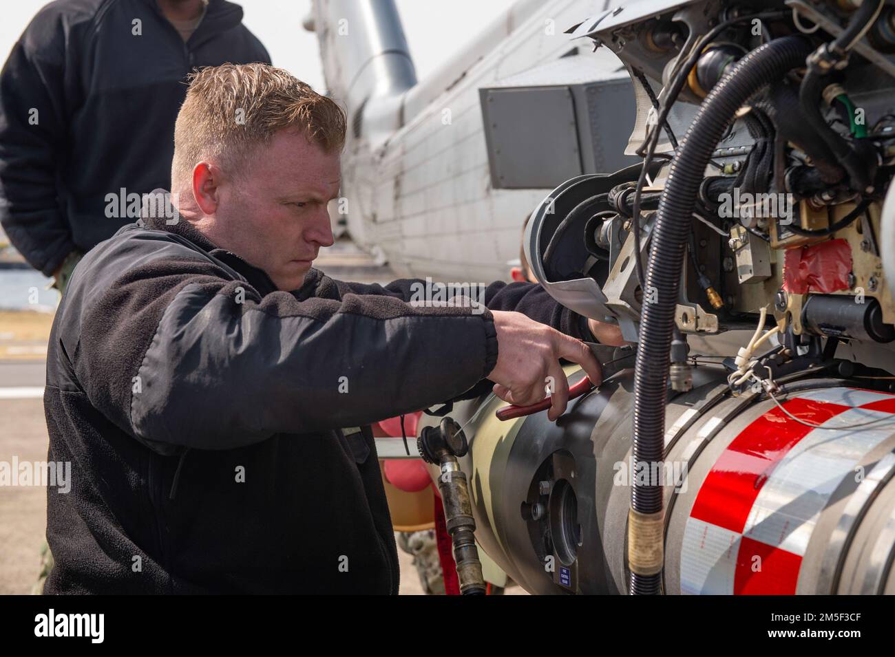 YOKOSUKA, Japan (10. März 2022) Chief Aviation Ordnanceman Spencer Holman, aus Seattle, sichert sich einen leichten Torpedo MK 54 an einen MH-60R Sea Hawk, der an den „Saberhawks“ des Helicopter Maritime Strike Squadron (HSM) 77 angehängt ist, während einer Übung bei Commander, Fleet Activities Yokosuka. Der MK 54 ist ein inerter Trainingstorpedo, der für Übungen wiederverwendet werden kann. HSM-77 ist dem Kommandeur der Task Force 70 angeschlossen und im Zuständigkeitsbereich der US-7.-Flotte zur Unterstützung eines freien und offenen Indo-Pacific eingesetzt. Stockfoto