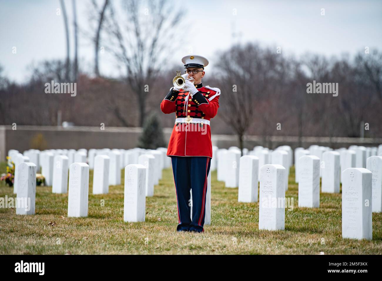 Ein Trompeter der Marine-Band „The President's Own“ spielt „Taps“ als Teil der militärischen Bestattungsfeier mit Begräbnisbegleitung für die USA Marinekorps CPL. Thomas Cooper in Sektion 57 des Arlington National Cemetery, Arlington, Virginia, 10. März 2022. Cooper wurde im Zweiten Weltkrieg im Alter von 22 Jahren getötet. Pressemitteilung der Defense POW/MIA Accounting Agency (DPAA): Im November 1943 war Cooper Mitglied von Unternehmen A, 2. Amphibious Tractor Battalion, 2. Marine Division, Fleet Marine Force, die gegen steifen japanischen Widerstand auf der kleinen Insel Betio im Tarawa-Atoll des Gilbert gelandet ist Stockfoto