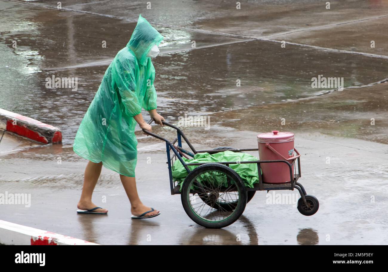 Ich transportiere Dinge in einem Wagen auf einer regnerischen Straße, Thailand Stockfoto