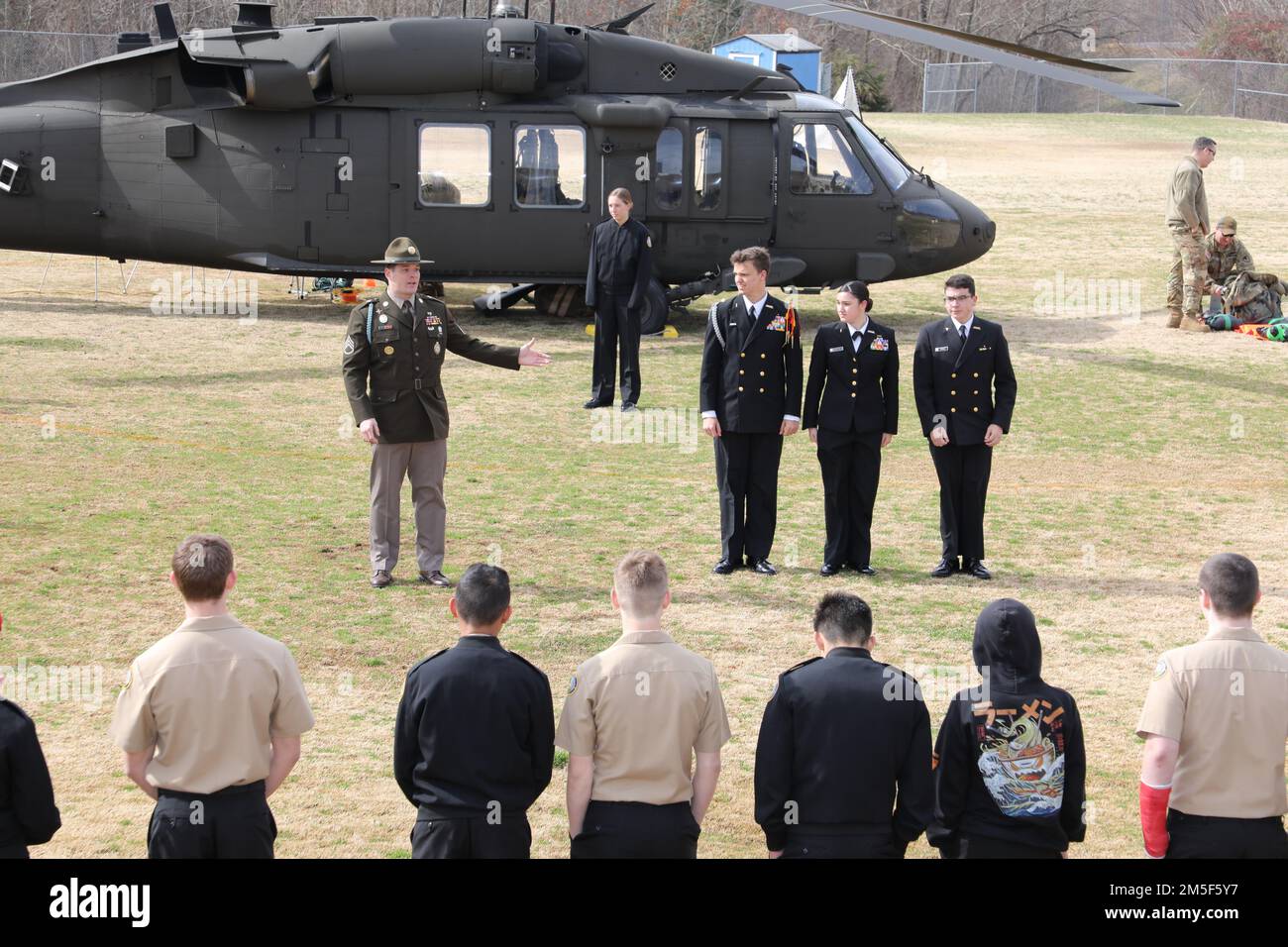 Staff Sgt. Gareth Ainsworth, ein nicht kommissionierter Bohrer und Rekrutierungs- und Haftungsoffizier des Maryland Army National Guard Bataillons für Rekrutierung und Rettung, hob drei JROTC-Kadetten der Navy während einer statischen Ausstellung der UH-60 Black Hawk an der Huntingtown High School in Huntingtown, Maryland, am 10. März 2022 hervor. Die drei Kadetten wurden für ihre Teilnahme an der Maryland Army National Guard während ihrer Einschreibung in der Highschool hervorgehoben. Stockfoto