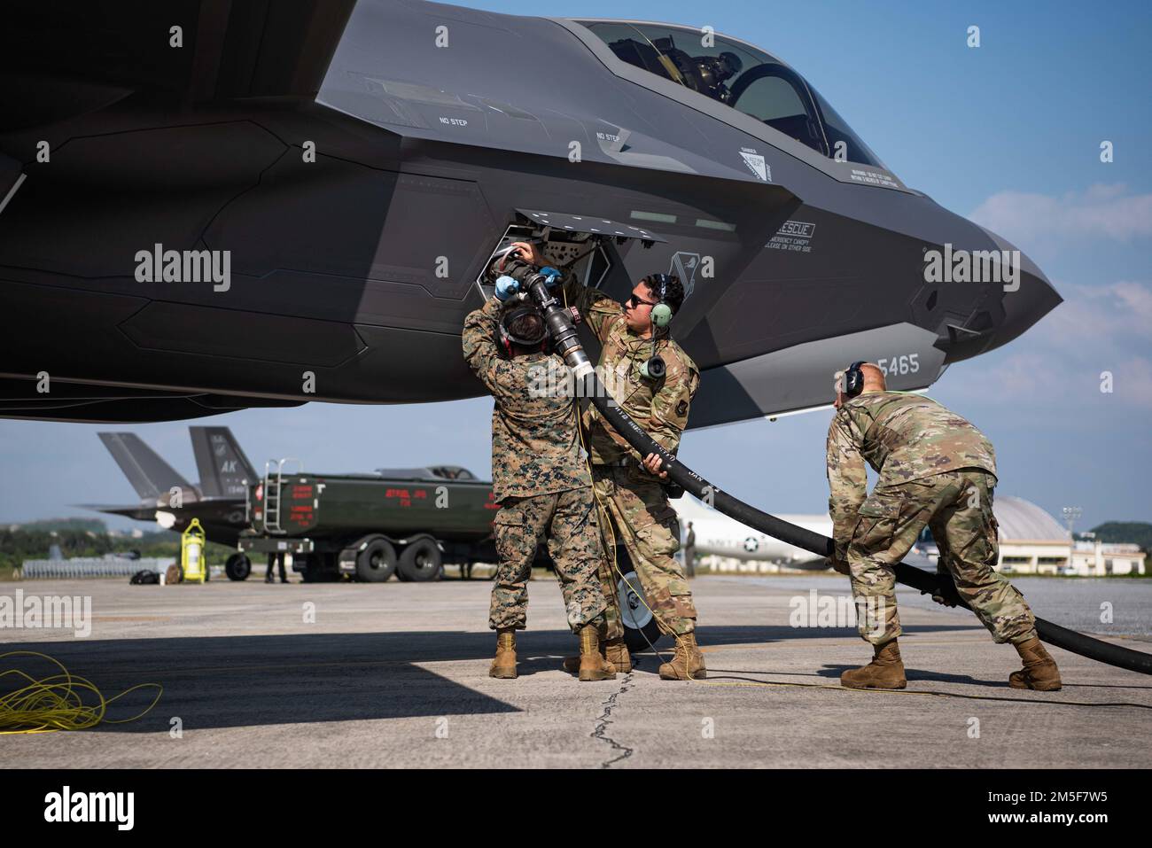 U.S. Marine Corps CPL. John Lopes, links, 3D Marine Logistics Group Bulk Fuel Specialist, Senior Airman der US Air Force Eduardo Elias-Vasquez, Mitte, 355. Expeditionary Fighter Squadron Crew Chief, And Airman 1. Class Cody Berry, rechts, 18. Logistics Readiness Squadron, Fuels Distribution Operator, betankt einen F-35A Lightning II, 354. Fighter Wing, Eielson Air Force Base, Alaska, während einer gemeinsamen Schulung zum Tanken von heißen Gruben auf dem Kadena Air Base, Japan, 10. März 2022. Gemeinsame Schulungen tragen zur Verbesserung der Interoperabilität bei, indem sie die Dienste mit der Fähigkeit ausstatten, während der Zusammenarbeit im Team effizienter zu arbeiten Stockfoto