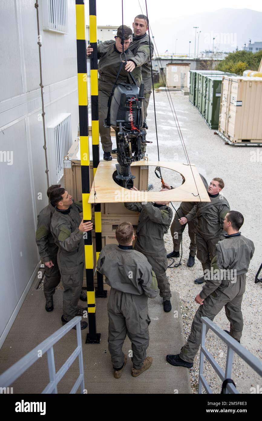 220310 -M-HU496-1006 SOUDA BAY, Griechenland (10. März 2022) USA Marines mit Task Group 61/2,4, Task Force 61/2 Probefahrt zum Anheben und Absenken eines Motors für ein Kampfgummi-Razzia-Schiff in ein U-Boot nahe Souda Bay, Griechenland 10. März 2022. Die Task Group 61/2,4 ist Teil der Task Force 61/2, einer schnell einsetzbaren und skalierbaren Koordinierungszelle, die den USA vorübergehend Befehls- und Steuerungsunterstützung bietet Sechster Flottenkommandeur, im Rahmen laufender Experimente. Stockfoto
