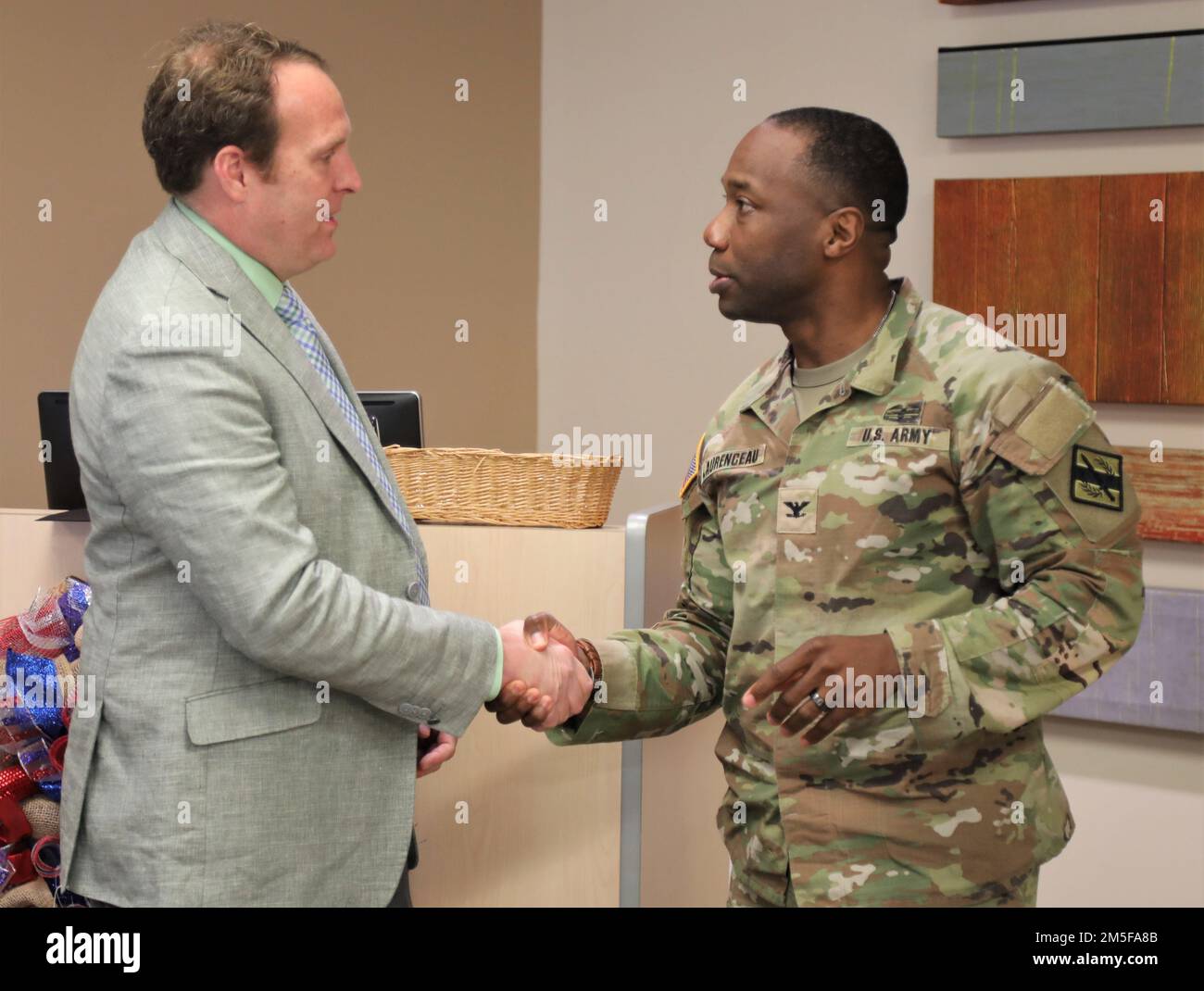 USA Armeekollege Jean-Paul Laurenceau, Befehlshaber der 201. Regionalen Unterstützungsgruppe in Marietta, Georgia Army National Guard, überreicht eine Münze an Matthew Crumpton, Emergency Preparedness Manager des Northeast Georgia Health System, am 11. März 2022 in Gainesville, Georgia. Crumpton überwachte aktivierte Georgia National Guardsmen, die im Krankenhaus als Reaktion auf COVID-19 assistierten. Stockfoto