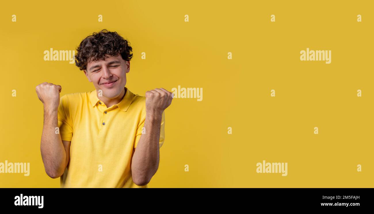 Locken-Mann zeigt Triumph Ja JA JA, Siegesgeste, Kopierraum. Banner. Er erreichte Ergebnisse, Ziele. Ein Mann, der glücklich ist, eine überraschende, glückliche Lady an Stockfoto