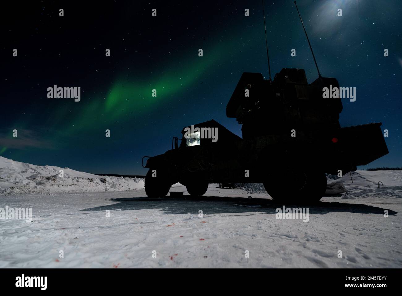 Die Nordlichter leuchten über einem Avenger Air Defense System, das dem 1. Bataillon, dem 265. Air Defense Artillery Regiment, Florida Army National Guard zugeteilt wurde, während der Übung ARCTIC EDGE 2022 am Eielson Air Force Base, Alaska, 11. März 2022. Das Luftabwehrsystem Avenger ist ein selbstfahrendes Boden-Luft-Raketensystem, das Bodeneinheiten vor Marschflugkörpern, unbemannten Luftfahrzeugen, tief fliegenden Starrflügelflugzeugen und Helikoptern schützt. Stockfoto