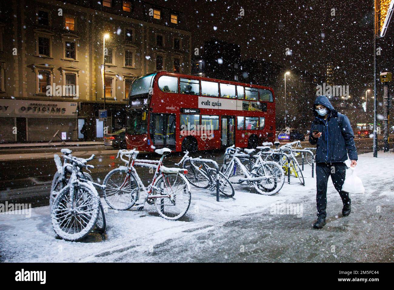 Schnee fällt auf den Fahrrädern, während ein Londoner Bus in Stockwell, Südwest-London, vorbeifährt, während ein unvorhergesehener Kälteversuch die Hauptstadt und einen Großteil des Südens abdeckt Stockfoto