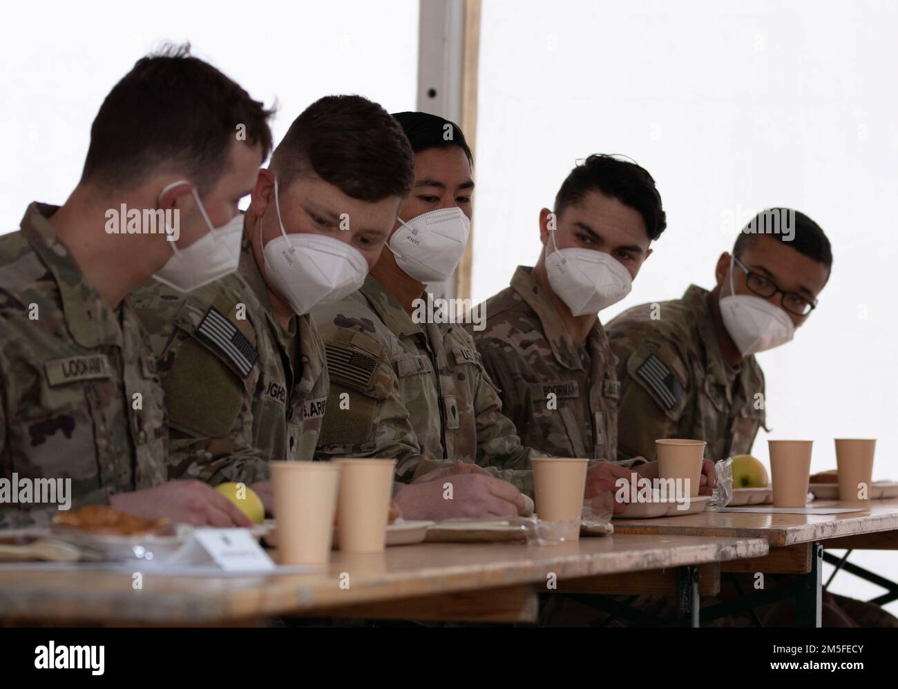 Soldaten der 1. Panzerbrigade-Kampfeinheit, 3. Infanterie-Division, erhalten Weisswurst, ein traditionelles bayerisches Essen, während eines Besuchs des bayerischen Ministerpräsidenten Markus Soder im Lager Achen auf dem Grafenwoehr-Trainingsgelände am 11. März 2022. Weisswurst ist eine bayerische Spezialität, die in Weißwurst übersetzt wird und traditionell zum Frühstück serviert wird. Der Besuch des Ministerpräsidenten brachte seine Unterstützung für die laufende NATO-Partnerschaft beider Nationen zum Ausdruck und bekräftigte die 65-jährige Freundschaft zwischen deutsch-bayerischen und amerikanischen Soldaten. Stockfoto