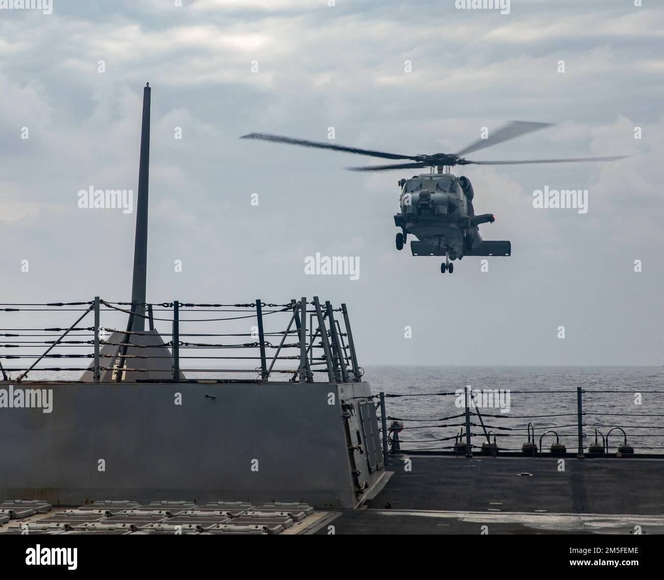 SÜDCHINESISCHES MEER (11. März 2022) ein MH-60R Seahawk, der an die „Warlords“ des Helicopter Maritime Strike Squadron (HSM) 51 angehängt ist, landet auf dem Flugdeck des Arleigh-Burke-Class-Guided-Missile Destroyers USS Ralph Johnson (DDG 114). Ralph Johnson ist der Task Force 71/Destroyer Squadron (DESRON) 15, dem größten nach vorn verlegten DESRON der Marine, und der Hauptstreitkraft der US-7.-Flotte zugewiesen. Stockfoto