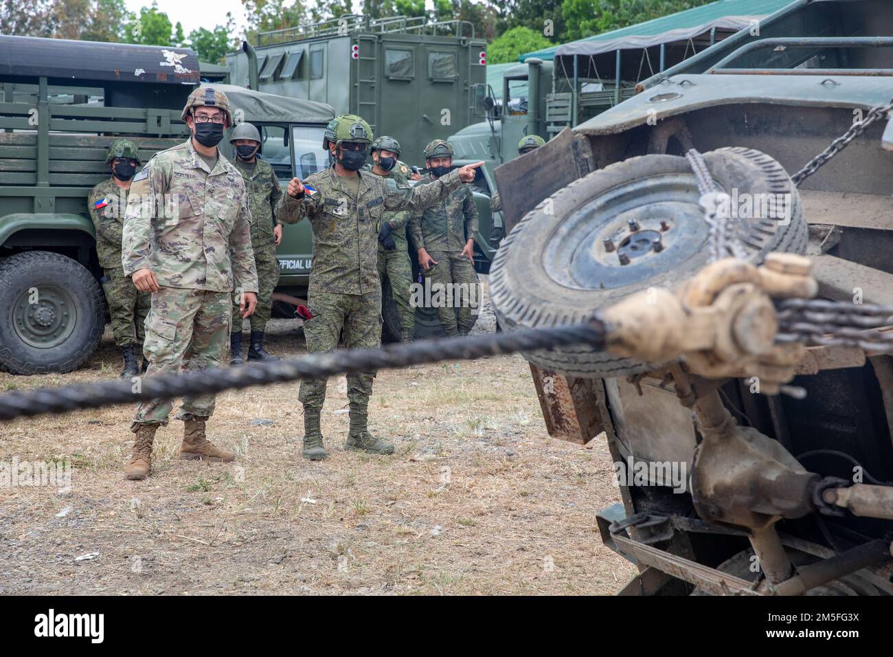 USA Army Sgt. Christian Castillo, ein Mechaniker für Radfahrzeuge bei B Company, 325. Brigaden-Stützbataillon, 3. Infanterie-Brigaden-Kampfteam, 25. Infanterie-Division, übt Handzeichen mit philippinischen Soldaten während einer Übung zur Fahrzeugbergung während Salaknib 2022 in Fort Magsaysay, Nueva Ecija, Philippinen, 12. März 2022. Salaknib wird jährlich von der philippinischen Armee geführt Von der Army Pacific gesponserte bilaterale Übung zur Verbesserung der Kapazitäten und der Interoperabilität der US-amerikanischen und der philippinischen Armee im gesamten Spektrum militärischer Operationen und zur Stärkung der Verbindungen zwischen den Truppen Stockfoto