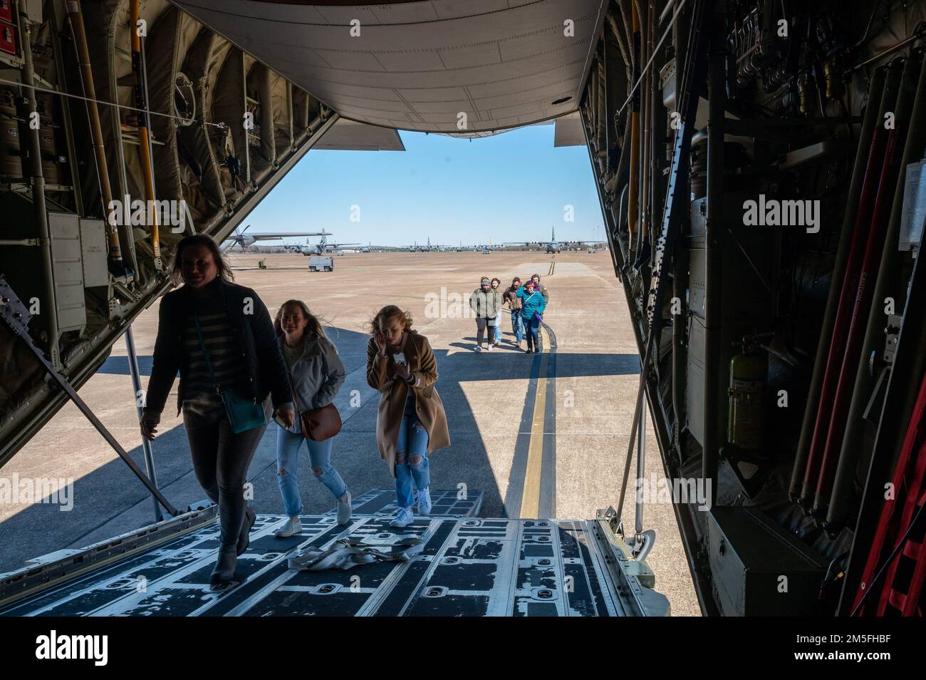 Eine Gruppe von Personen besteigt einen C-130J Super Hercules während einer Veranstaltung zum Ehepartner-Tag am Little Rock Air Force Base, Arkansas, 13. März 2022. Militärpartner und ihre Familien erhielten während der Veranstaltung die Möglichkeit, eine C-130J zu besichtigen und an einem Orientierungsflug an Bord des Flugzeugs teilzunehmen. Stockfoto