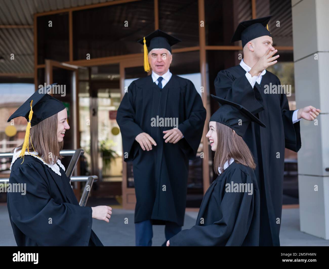 Klassenkameraden in Abschlusskleidern. Barrierefreie Bildung für alle Altersgruppen. Stockfoto