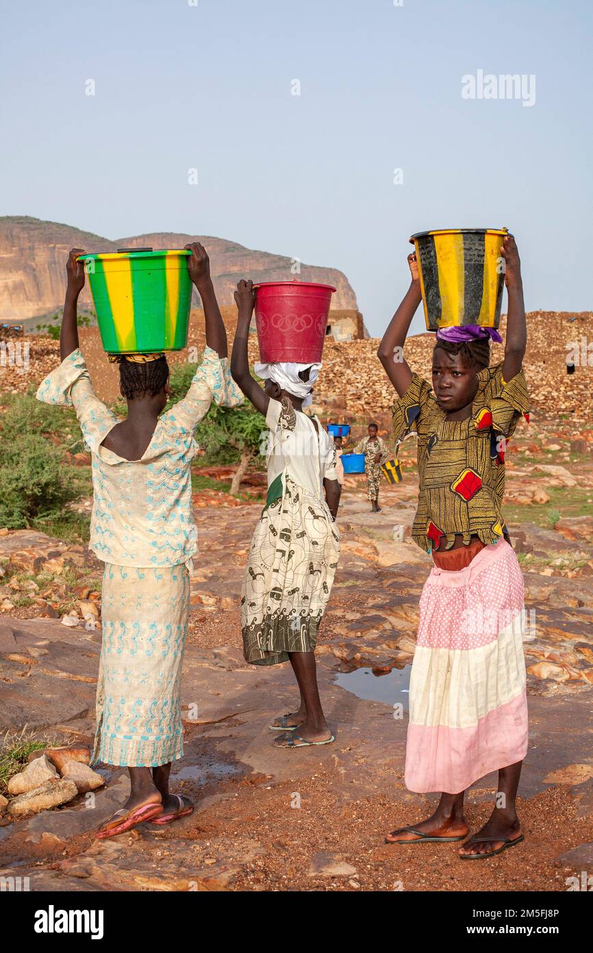 Zwei afrikanische Kinder, die Wasser zu ihrem Haus transportieren.Hombori, Mali, Westafrika.fast 1 Milliarden Menschen weltweit haben keinen Zugang zu sauberem Wasser. Stockfoto