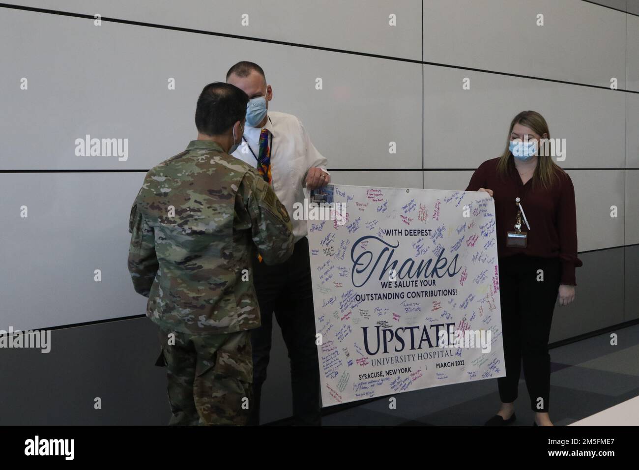 SYRACUSE, NEW YORK – Mitarbeiter des Upstate University Hospital präsentieren Danksagungsbanner an das militärisch-medizinische Team, das die COVID-Maßnahmen in ihrem Krankenhaus in Syracuse, New York, unterstützt, 14. März 2022. USA Nördliches Kommando, durch die USA Army North ist nach wie vor entschlossen, das Verteidigungsministerium flexibel bei der COVID-Reaktion der gesamten Regierung zu unterstützen. Stockfoto