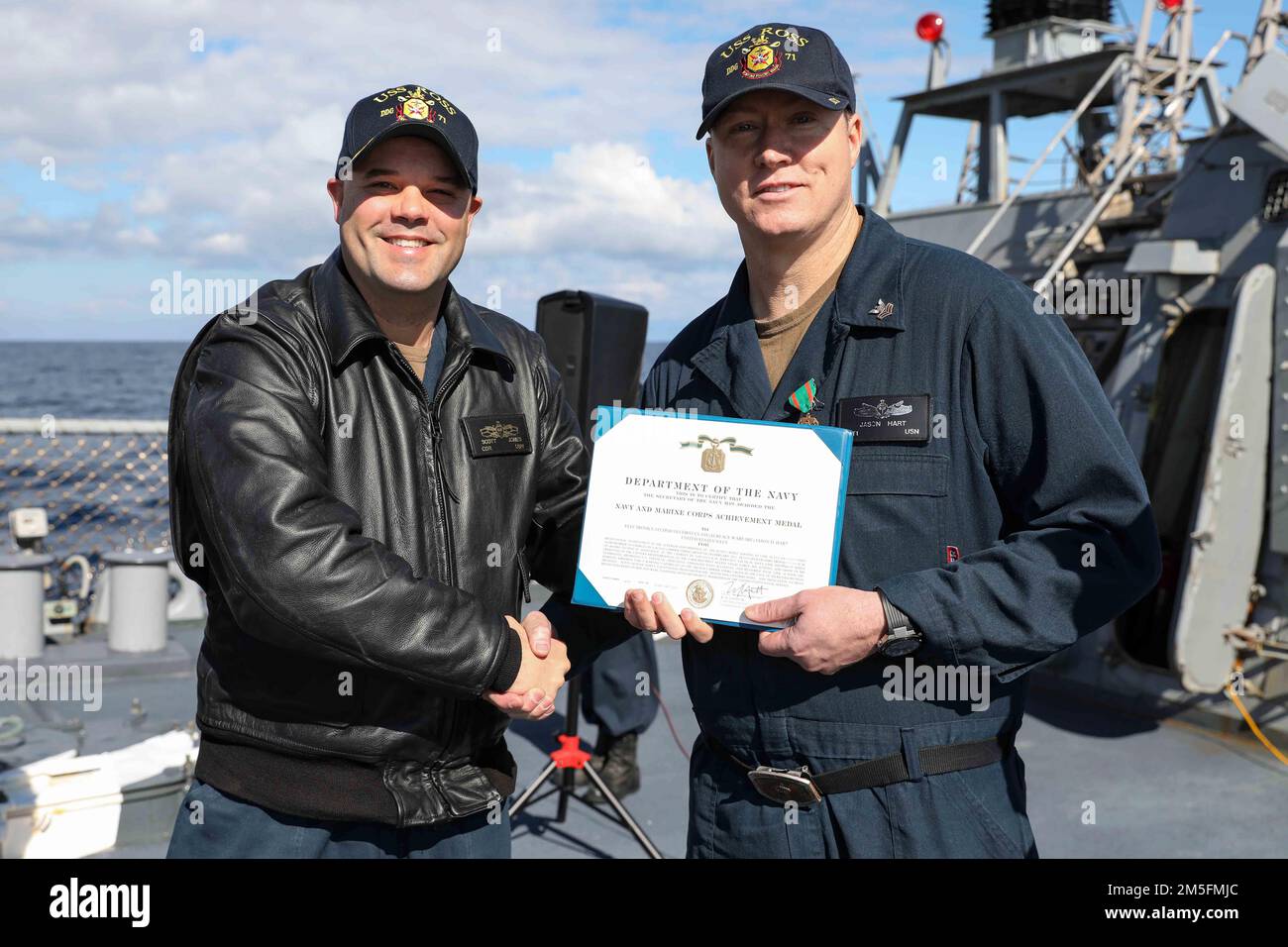 220314-N-UN585-1008 MITTELMEER (14. März 2022) Cmdr. Scott Jones, befehlshabender Offizier des Arleigh-Burke-Klasse-Guided-Missile Destroyers USS Ross (DDG 71), Left, überreicht dem Electronics Technician 1. Class Jason Hart, März 14, ein Marinekorps-Achievement-Zertifikat. Ross, nach Rota, Spanien, ist auf seiner 12. Patrouille in den USA Sechster Einsatzbereich der Flotte zur Unterstützung regionaler Verbündeter und Partner sowie nationaler Sicherheitsinteressen der USA in Europa und Afrika. Stockfoto