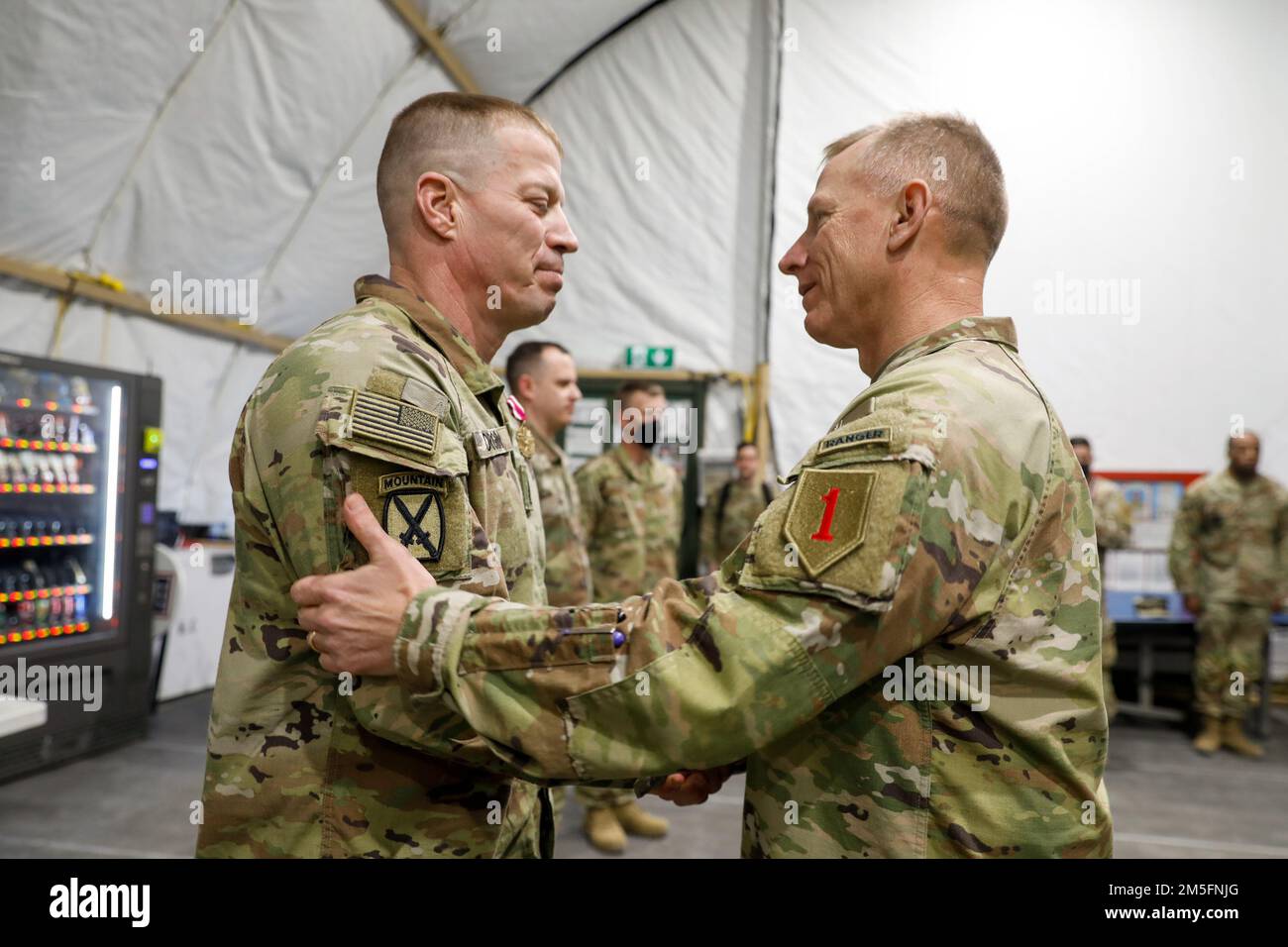 USA Generalmajor Douglas Sims, kommandierender General der 1. Infanteriedivision, gratuliert den USA Oberfeldwebel Donald Durgin, Oberfeldwebel des 1. Bataillons, 5. Artilleriegesiment, 1. Kampfteam der Panzerbrigade, 1. Infanteriedivision in Torun, Polen, 14. März 2022. Durgin war 18 Monate lang Oberfeldwebel von 1-5FA und sorgte dafür, dass die Soldaten ihre Missionen verrichteten und die Einheit funktionierte. Stockfoto