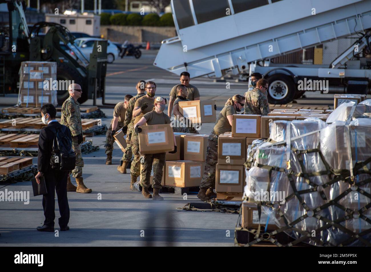 USA Air Force Airmen vom 730. Air Mobility Squadron, der 515. Air Mobility Operations Group und Soldaten der Japan Ground Self-Defense Force entladen und sortieren humanitäre Hilfsgüter der japanischen Regierung auf Luftfrachtpaletten am Yokota Air Base, Japan, 14. März 2022. Die japanische Regierung stellte der Ukraine 38 Tonnen humanitärer Hilfsgüter zur Verfügung und arbeitete mit den USA zusammen Air Force Airmen vom 730. Air Mobility Squadron und der 515. Air Mobility Operations Group liefern, verpacken und bereiten Luftfracht vor. Stockfoto