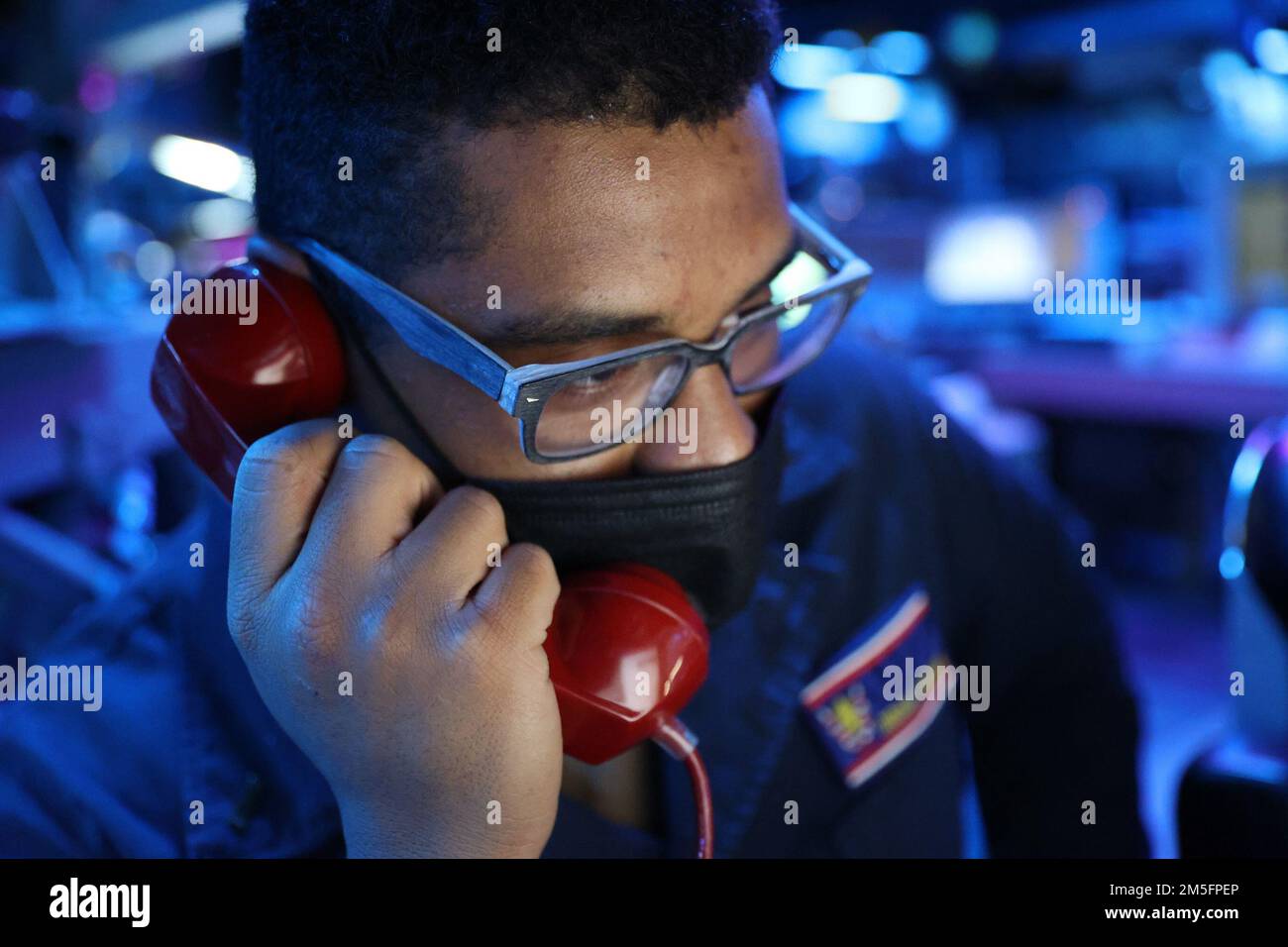 220314-N-CX281-1002 PHILLIPINE SEA (14. März 2022) Fähnrich Brian Parham nimmt den Anruf als Wachoffizier des Combat Information Center an Bord der Arleigh-Burke-Klasse, der Guided-Missile Destroyer USS Barry (DDG 52) entgegen. Die USS Barry ist der Destroyer-Staffel (DESRON) 15 zugeteilt und unterstützt derzeit ein freies und offenes Indo-Pacific. CTF 71/DESRON 15 ist die größte nach vorn verlegte DESRON-Flotte der Marine und die größte Oberflächenkraft der US-7.-Flotte. Stockfoto