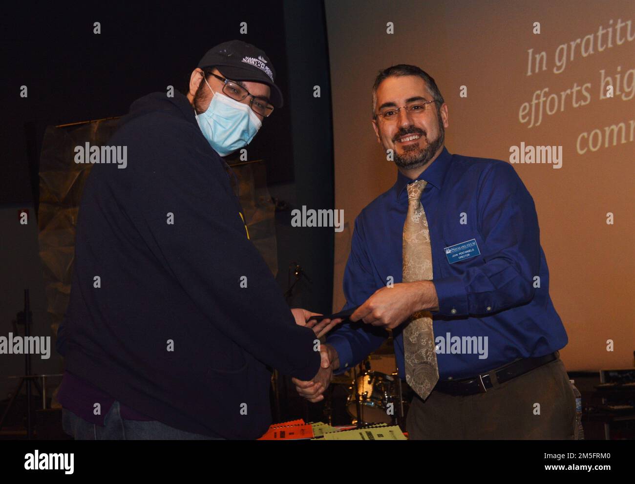 Museum Volunteer und Intern Paul Hanna (links) erhalten ein freiwilliges Dankeszertifikat, das John Pentangelo (rechts), Direktor des Hampton Roads Naval Museum, während einer ehrenamtlichen Veranstaltung überreicht. Das Museum befindet sich im zweiten Stock des Nauticus-Gebäudes in Downtown Norfolk, Virginia und ist eines von 10 US-amerikanischen Marinemuseen, die in das Naval History and Heritage Command fallen. Das Museum beherbergt auch ein robustes Freiwilligenkorps. Stockfoto