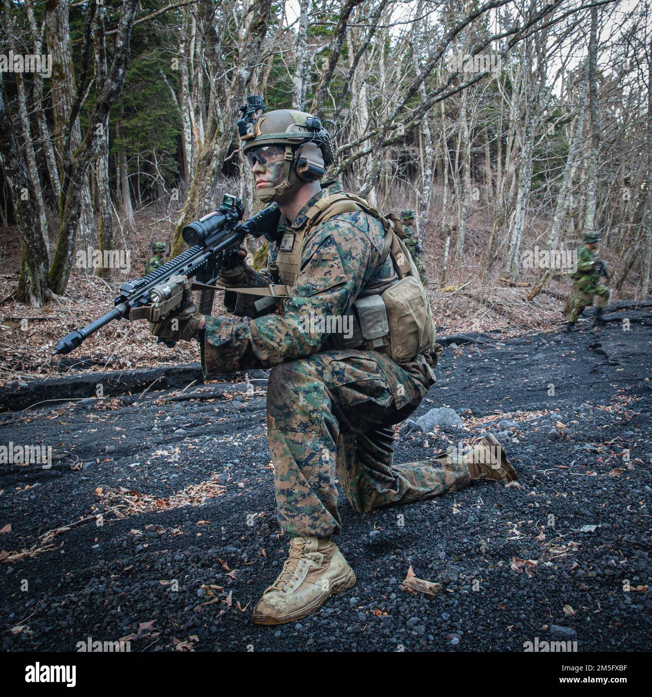 EIN US-AMERIKANISCHER Marine mit Bataillon Landing Team 1/5, 31. Marine Expeditionary, postet Sicherheitskräfte für Soldaten mit dem Amphibien Rapid Dispatch Regiment 1., japanische Boden-Selbstverteidigungstruppe, während einer Hubschrauberrazzia Übungsübung im Combined Arms Training Center Camp Fuji, Japan, 15. März 2022. Die Übung wurde durchgeführt, um Kenntnisse in der schnellen Ergreifung und Verteidigung von Schlüsselgelände zu entwickeln. Die maritime Verteidigungsübung Amphibious Rapid Deployment Brigade ist eine bilaterale Übung, die die Interoperabilität verbessern und die Beziehungen zwischen den US-amerikanischen und japanischen Streitkräften zur Verteidigung Japans stärken soll Stockfoto