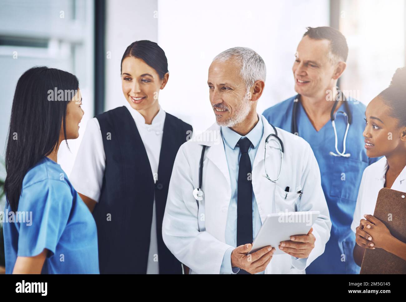 Diskussion über Fortschritte in der Medizintechnik. Ein Team von medizinischen Fachleuten diskutiert Arbeit über ein Tablet. Stockfoto