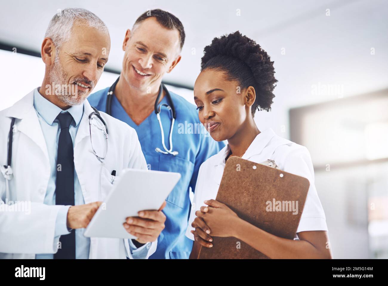 Technologie ist eine große Hilfe bei der Suche nach dem Gesundheitswesen. Ein Team von medizinischen Fachleuten diskutiert Arbeit über ein Tablet. Stockfoto