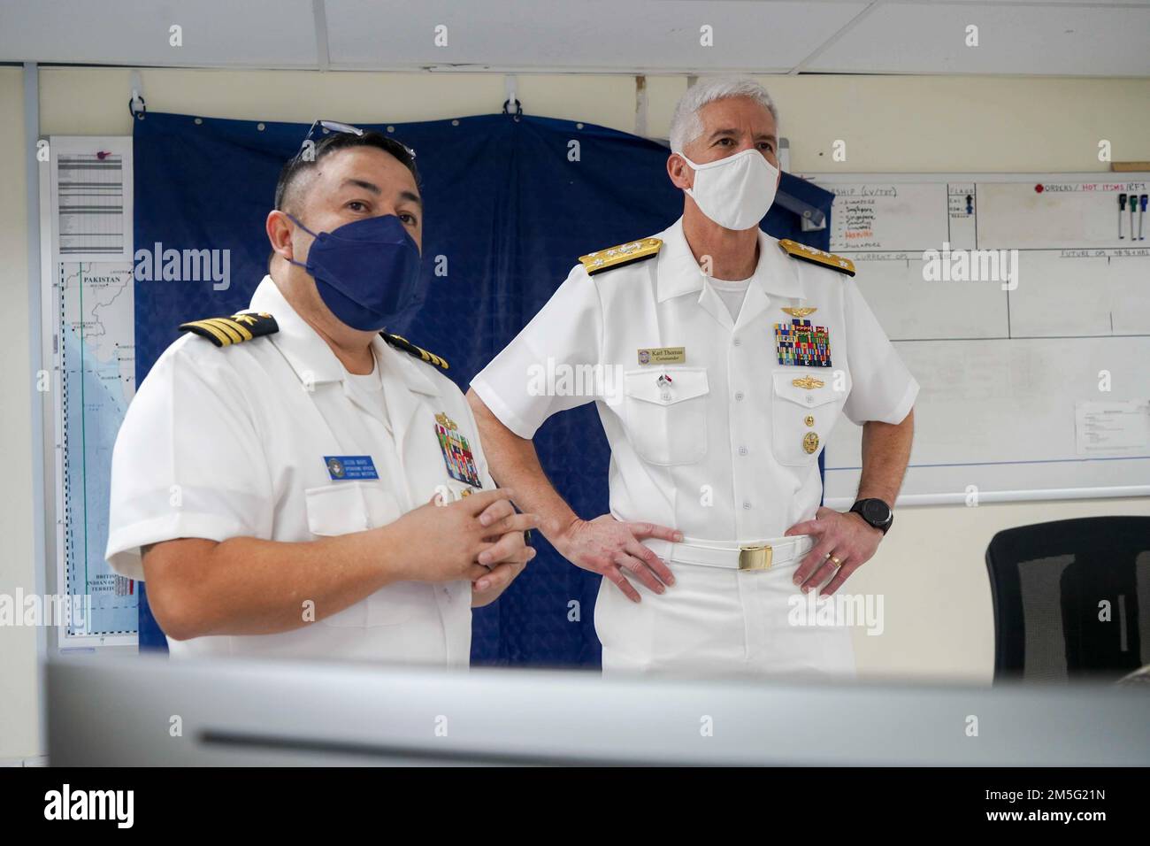 220316-N-JC800-0008 SINGAPUR (16. MÄRZ 2022) – (von links) Cmdr. Jason ward, Leiter der Einsatzabteilung des Befehlshabers, Logistics Group Western Pacific (COMLOG WESTPAC)/Task Force 73, gibt Rückwärtstrieb Karl Thomas, Commander, 7. Fleet während einer geplanten Tour durch COMLOGWESTPAC. Stockfoto