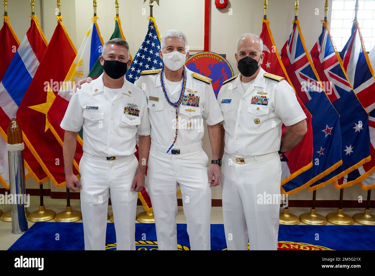 220316-N-JC800-0021 SINGAPUR (16. MÄRZ 2022) – (von links) Chief Boatswain's Mate John Karus, dem militärischen Sealift Command Far East, Rear ADM zugewiesen. Karl Thomas, Commander, 7. Fleet und Rear ADM. Philip Sobeck, Commander, Logistics Group Western Pacific (COMLOG WESTPAC)/Task Force 73, ex6change Geschenke während einer geplanten Tour durch COMLOGAC. Stockfoto