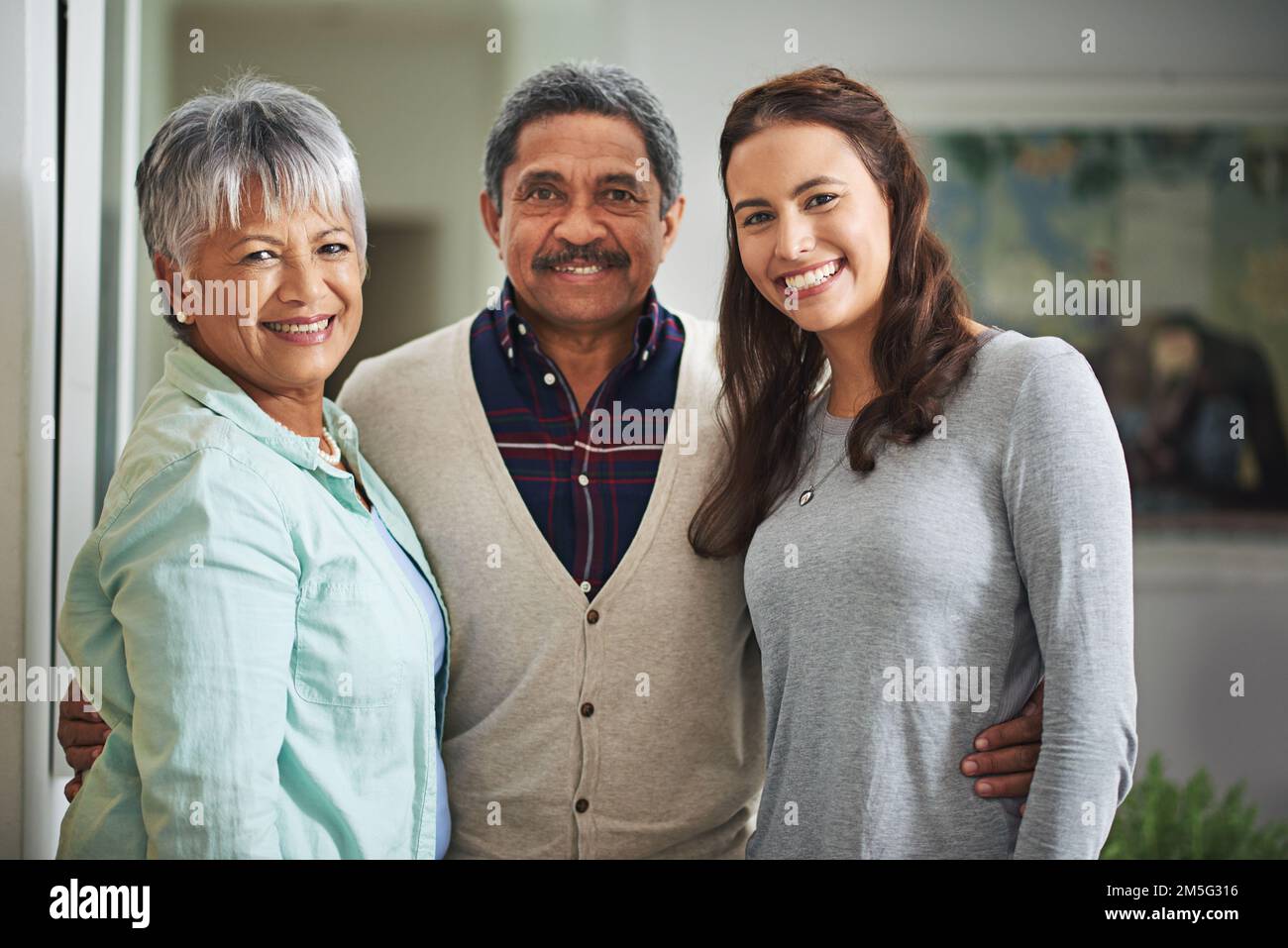 Dad und seine zwei Lieblinge. Gekürztes Porträt einer jungen Frau und ihrer erwachsenen Eltern zu Hause. Stockfoto