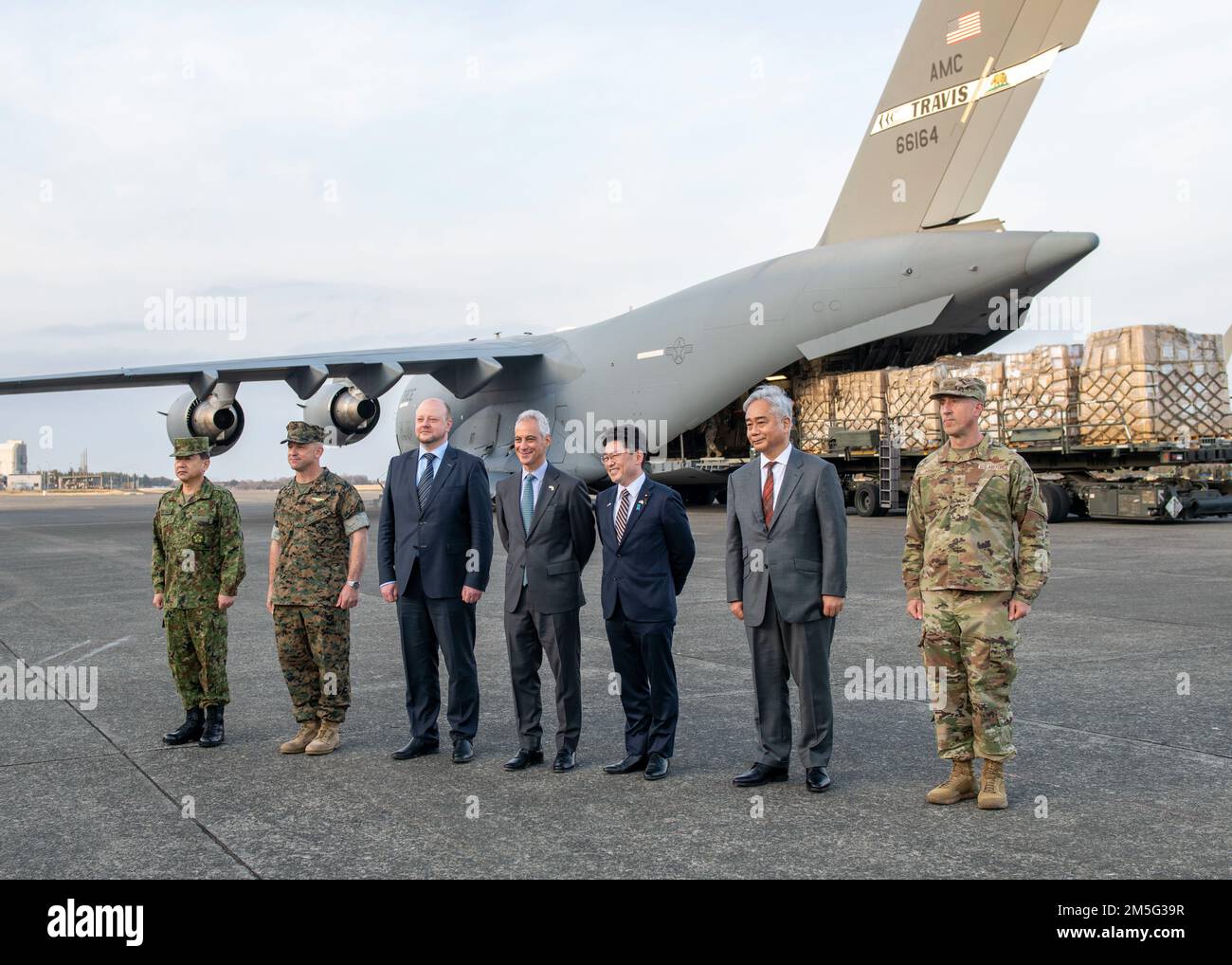 Rahm Emanuel, USA Botschafter in Japan (Mitte), Oniki Makoto, japanischer Staatsminister für Verteidigung (Mitte rechts), und Oleksandr Semenyuk, Stellvertretender Leiter der ukrainischen Botschaft in Japan (Mitte links), arbeiten mit der US-amerikanischen und japanischen Militärführung zusammen Air Force C-17 Globemaster III lädt Fracht der japanischen Regierung für humanitäre Hilfe auf den Luftwaffenstützpunkt Yokota, Japan, 16. März 2022. Im Rahmen einer gemeinsamen Anstrengung arbeiteten alle Mitglieder des US-amerikanischen und japanischen Militärs mit ihren Amtskollegen in den USA zusammen Die Botschaft, das japanische Verteidigungsministerium und die ukrainische Botschaft, um die schnell zu koordinieren Stockfoto